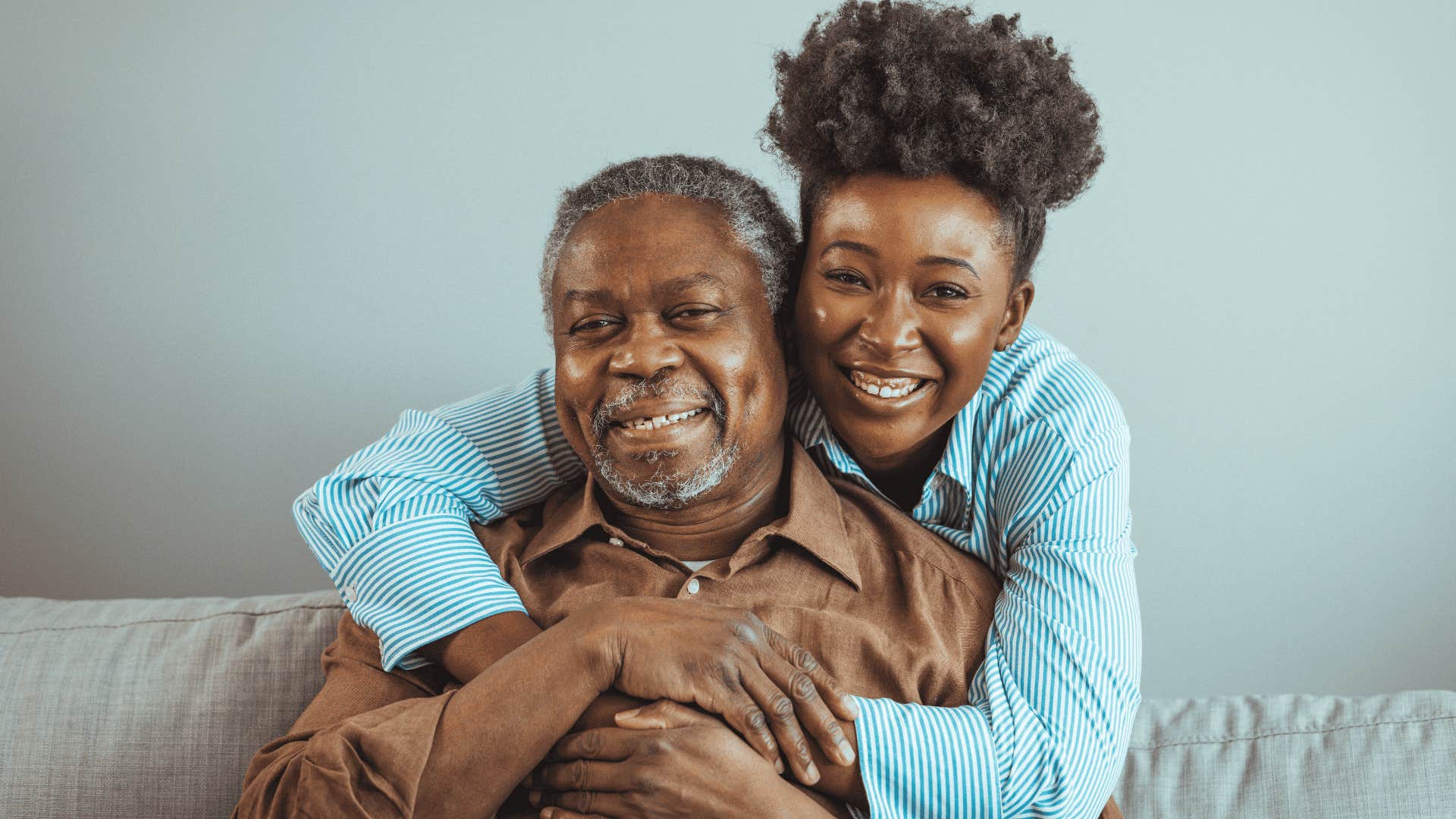 adult daughter smiling and hugging her dad
