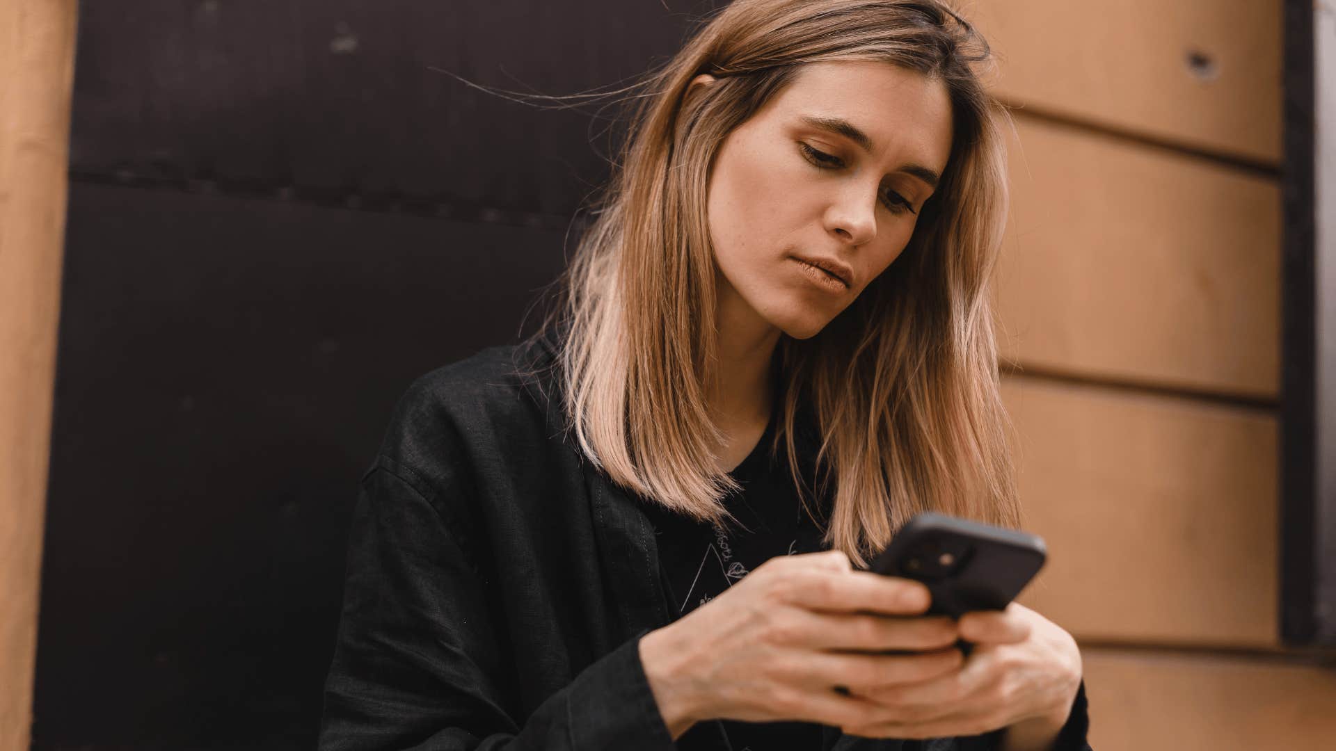 serious young woman texting on her phone