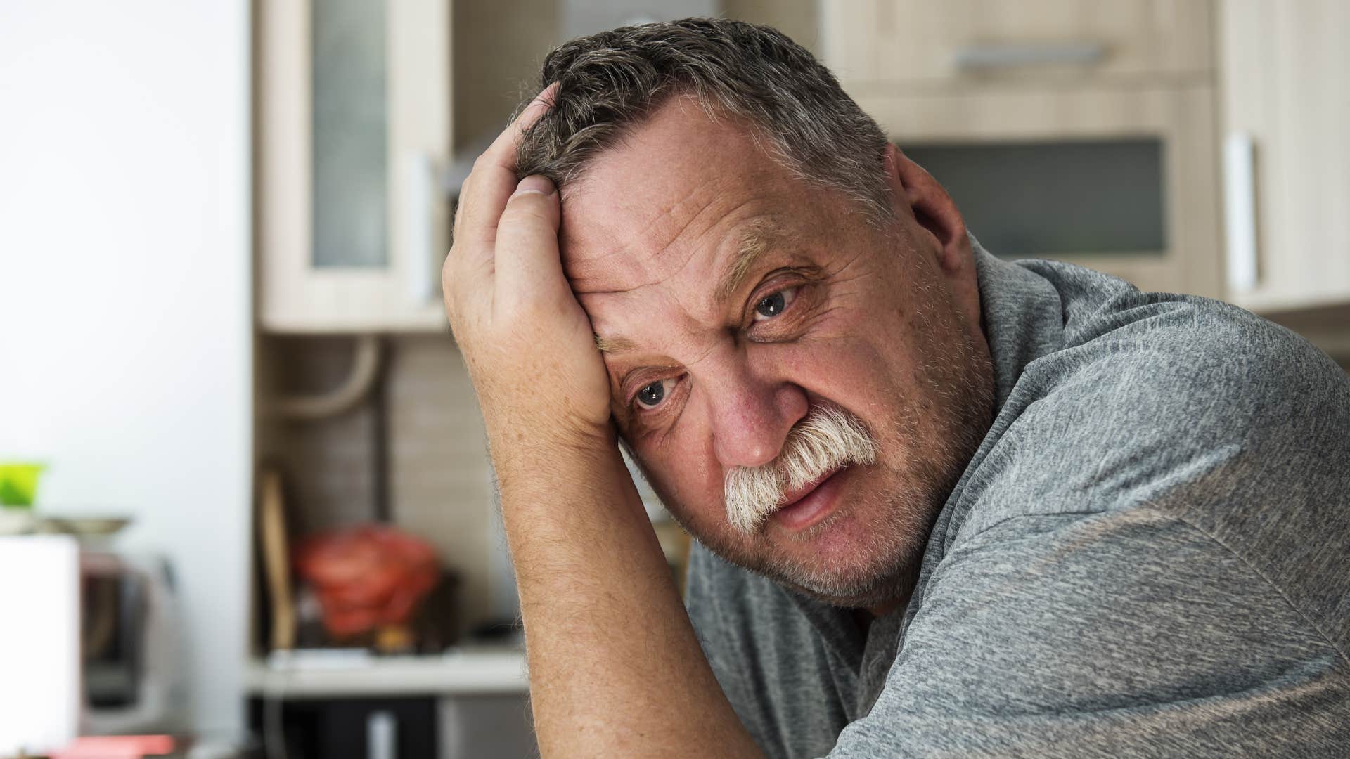 man is emotionally detached because he's exhausted but pretending to be ok
