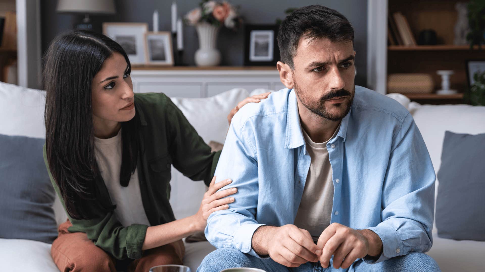 woman trying to comfort her defensive husband