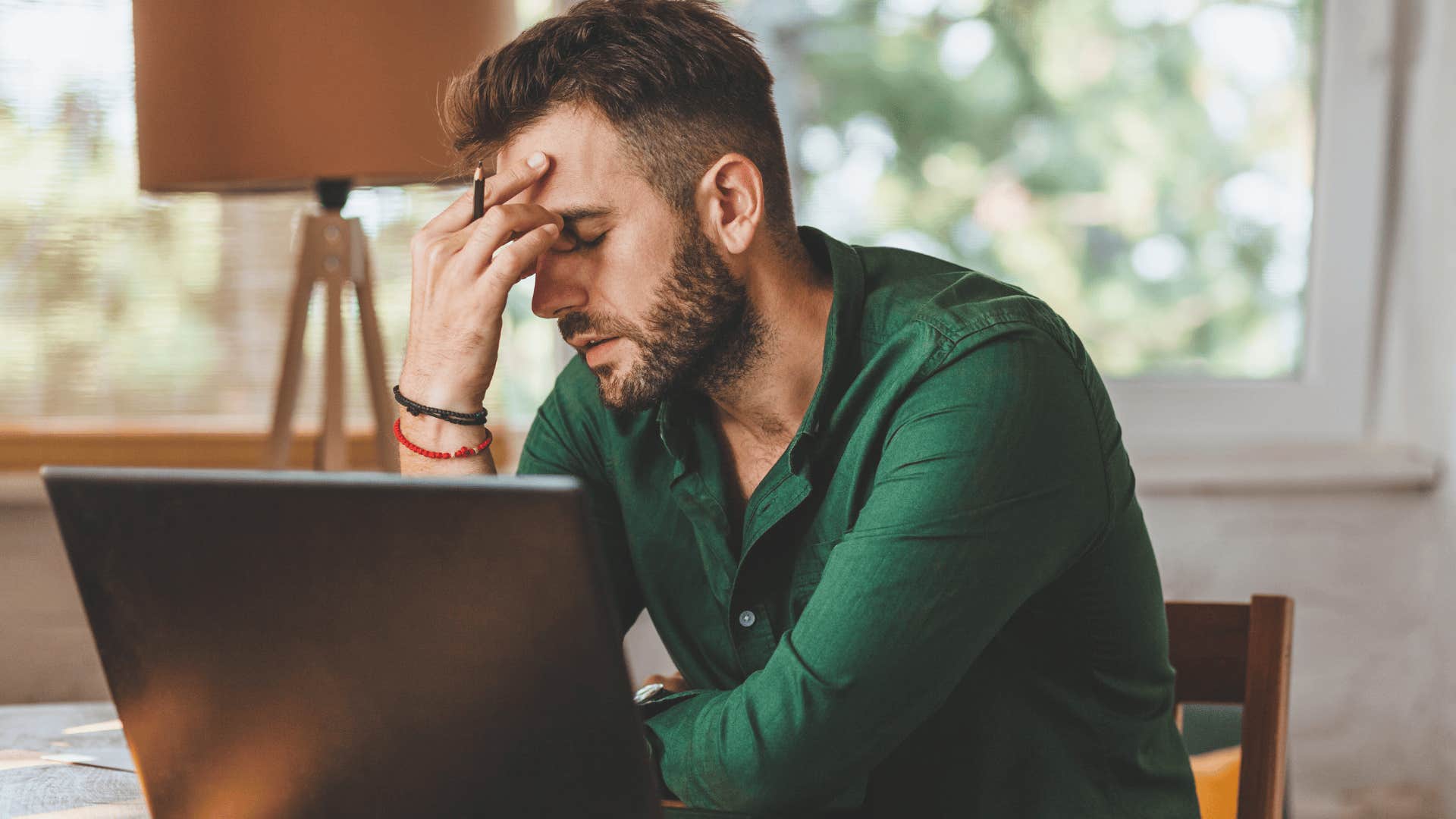 stressed man holding his temple