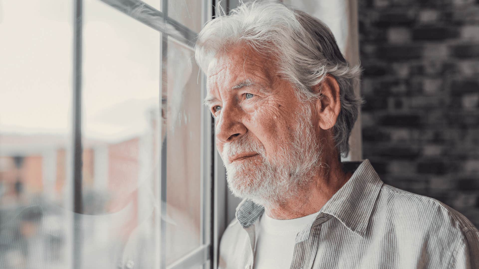 sad older man looking outside