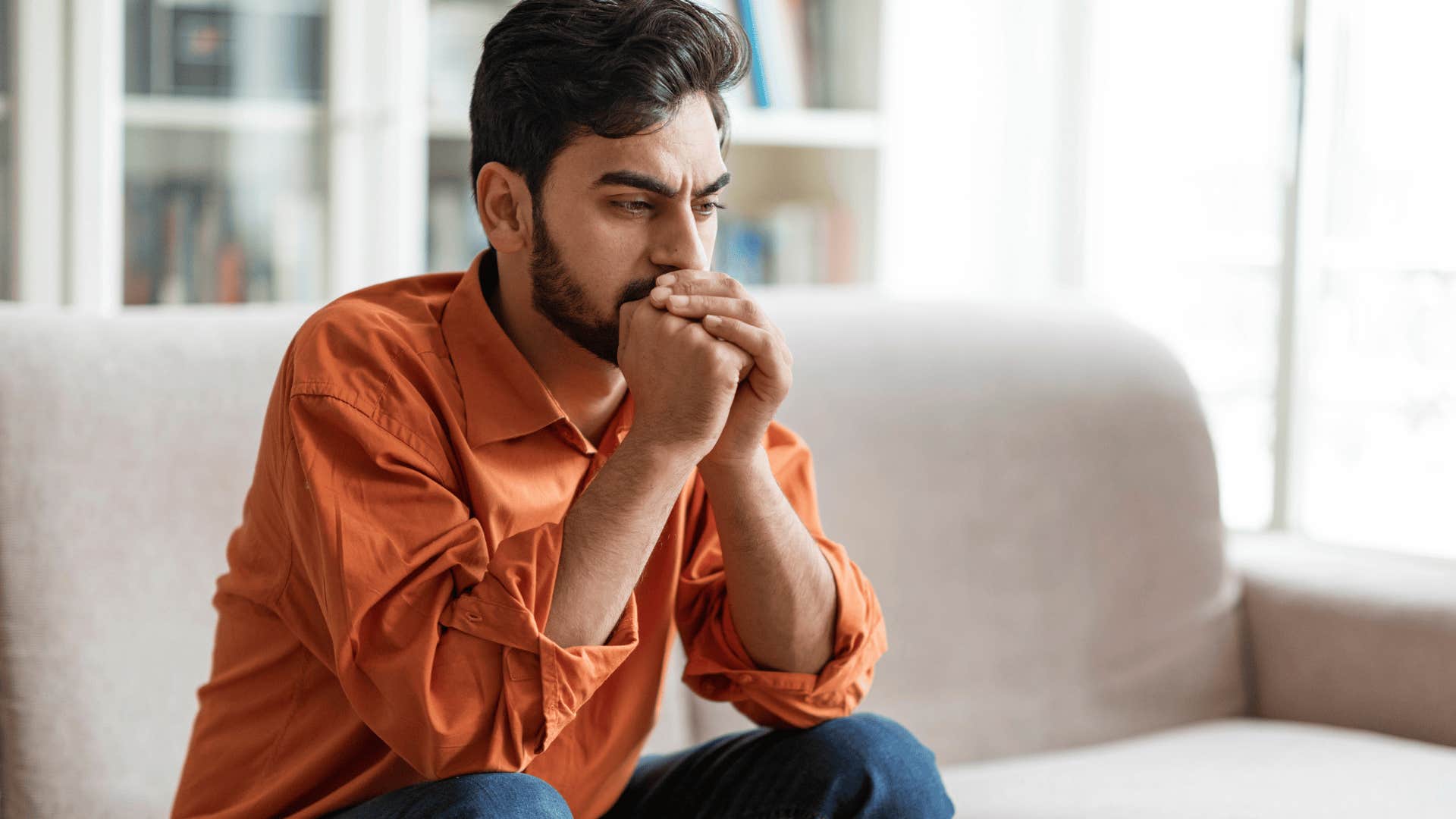 distressed man holding his head in his hands
