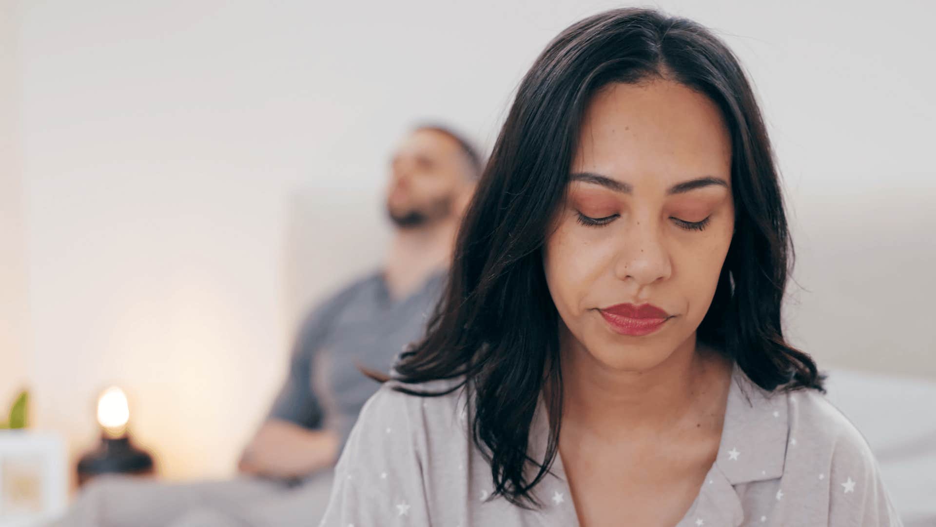 woman thinking while husband sits behind her