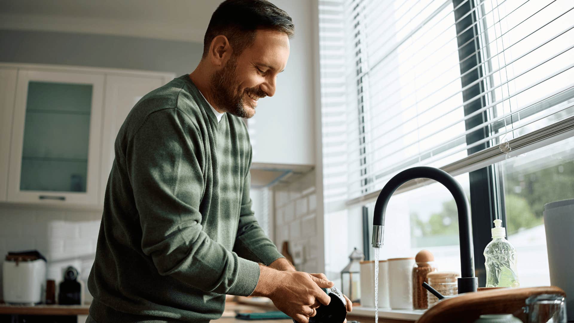 man smiling and doing dishes