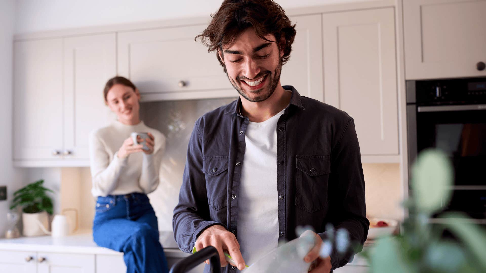 man happily cooking dinner for wife