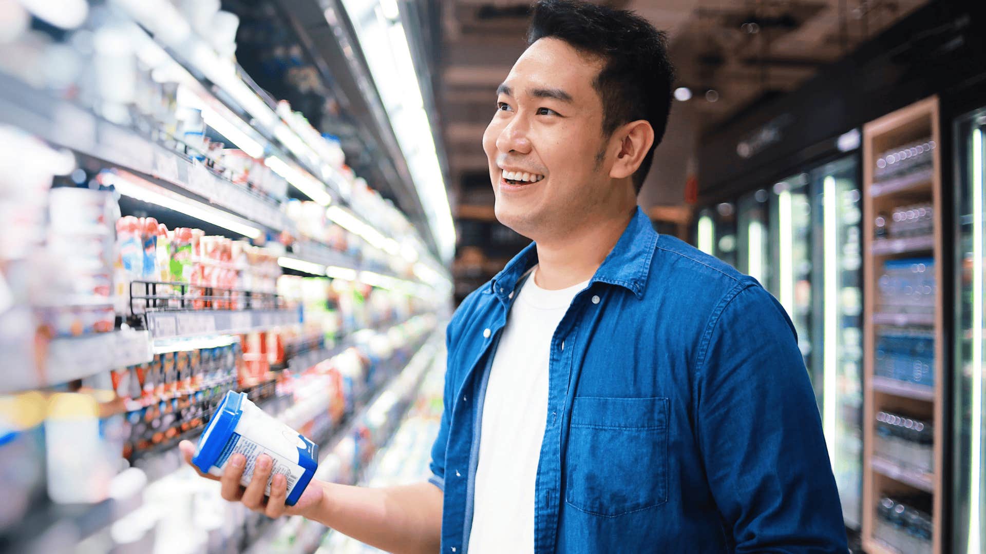 man happily shopping at the grocery store