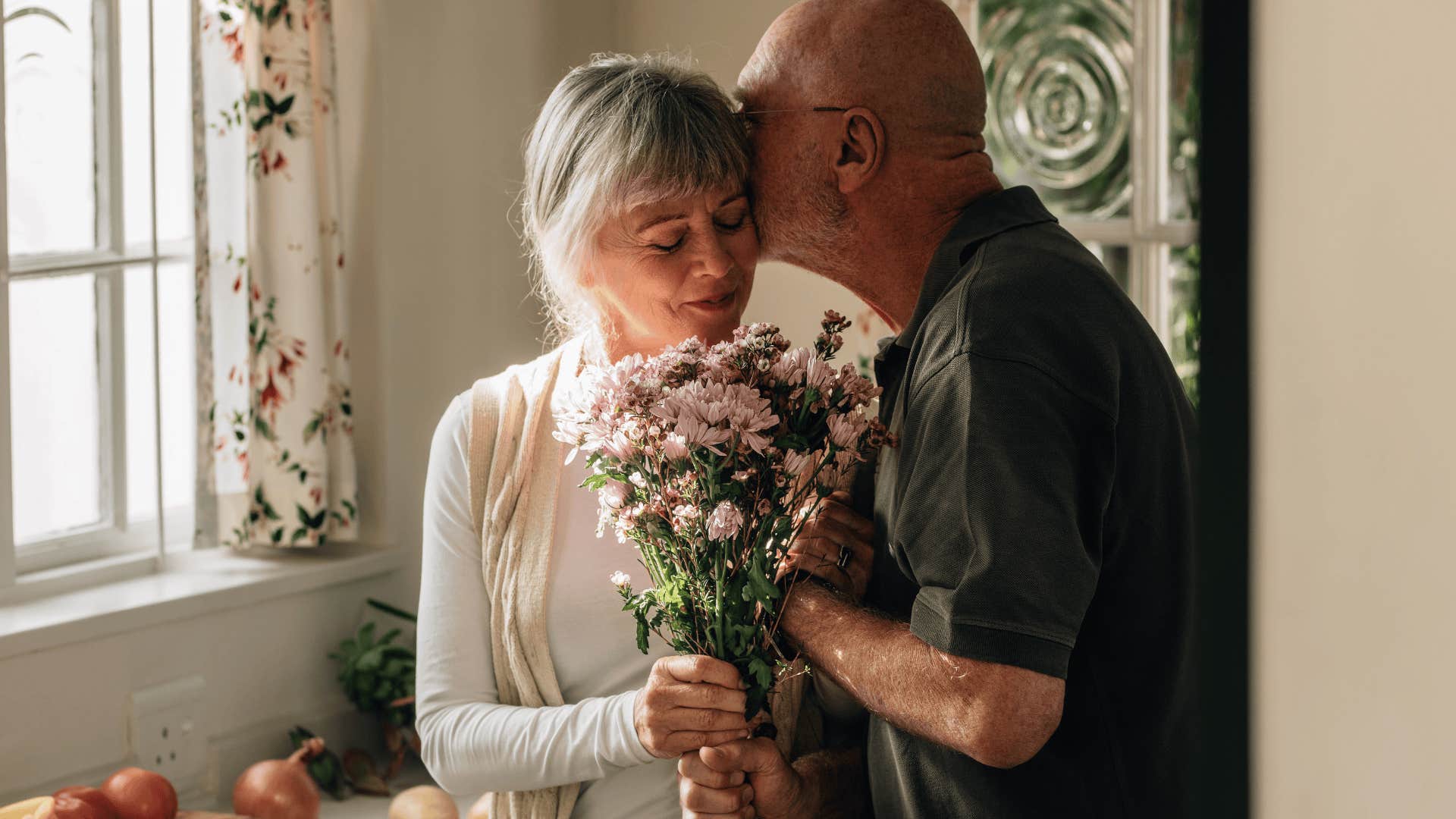 older man giving his wife flowers