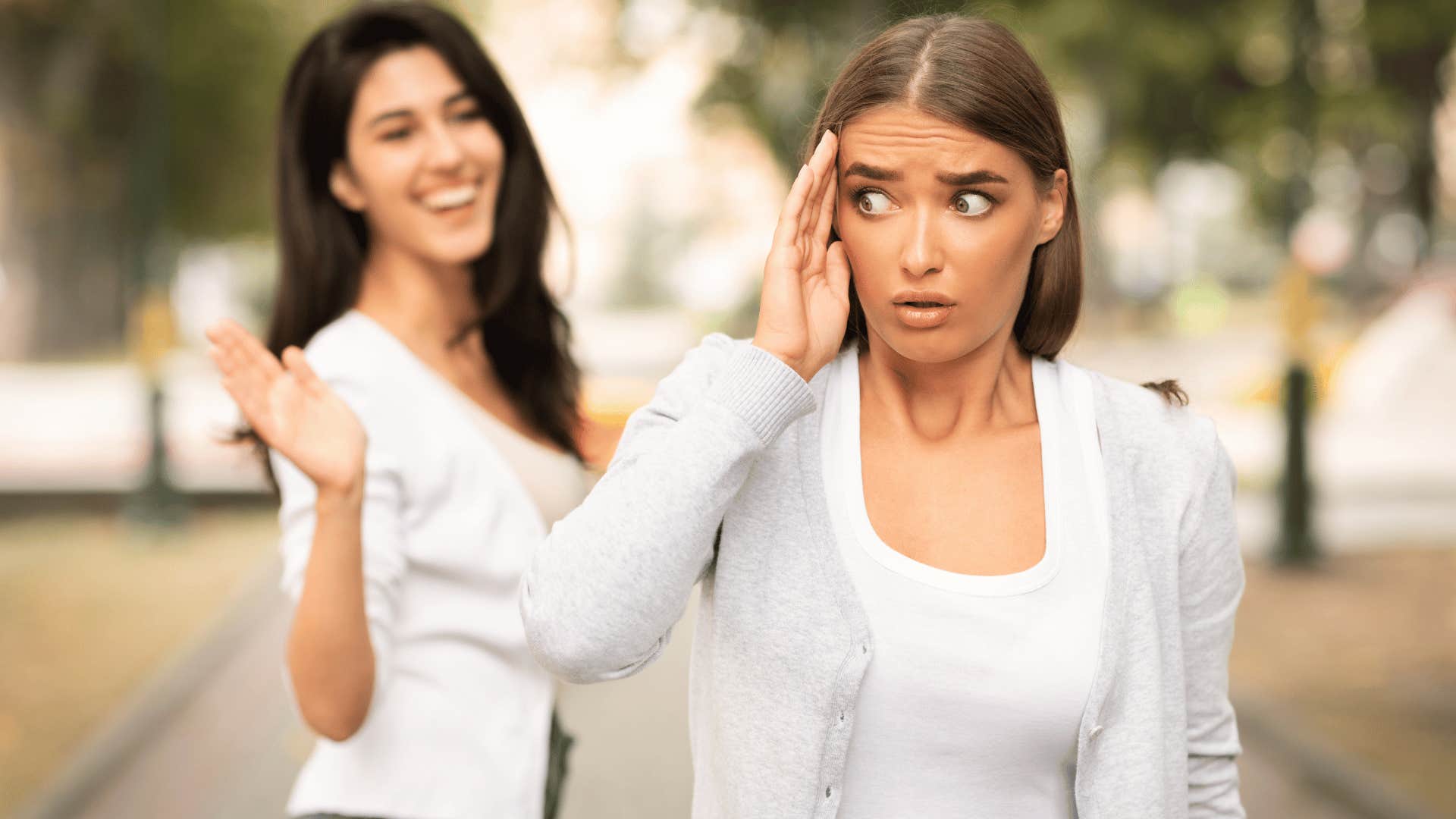 woman ignoring other woman waving at her