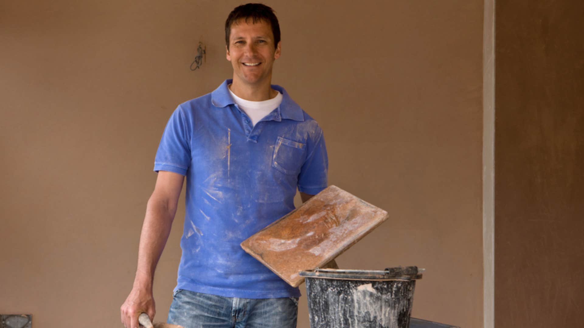 man with DIY mentality painting home himself