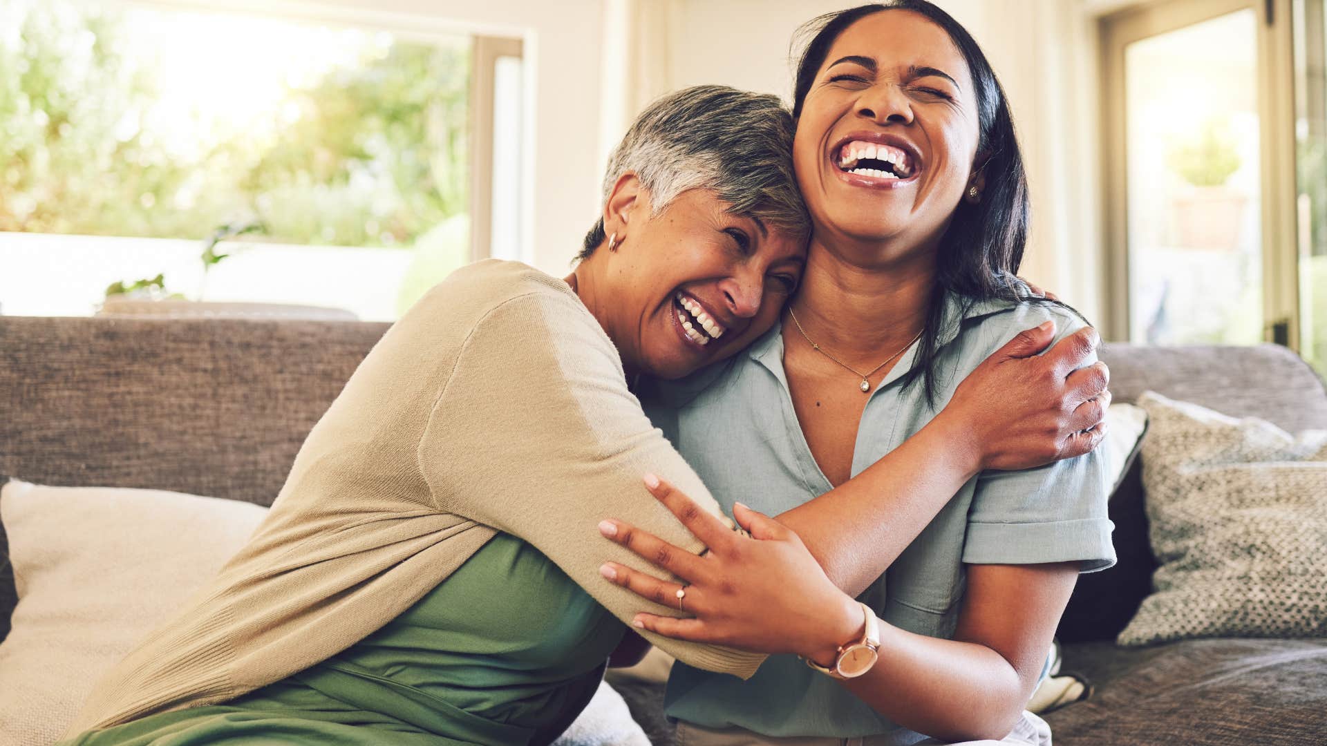 Gen X mom smiling and hugging her adult daughter