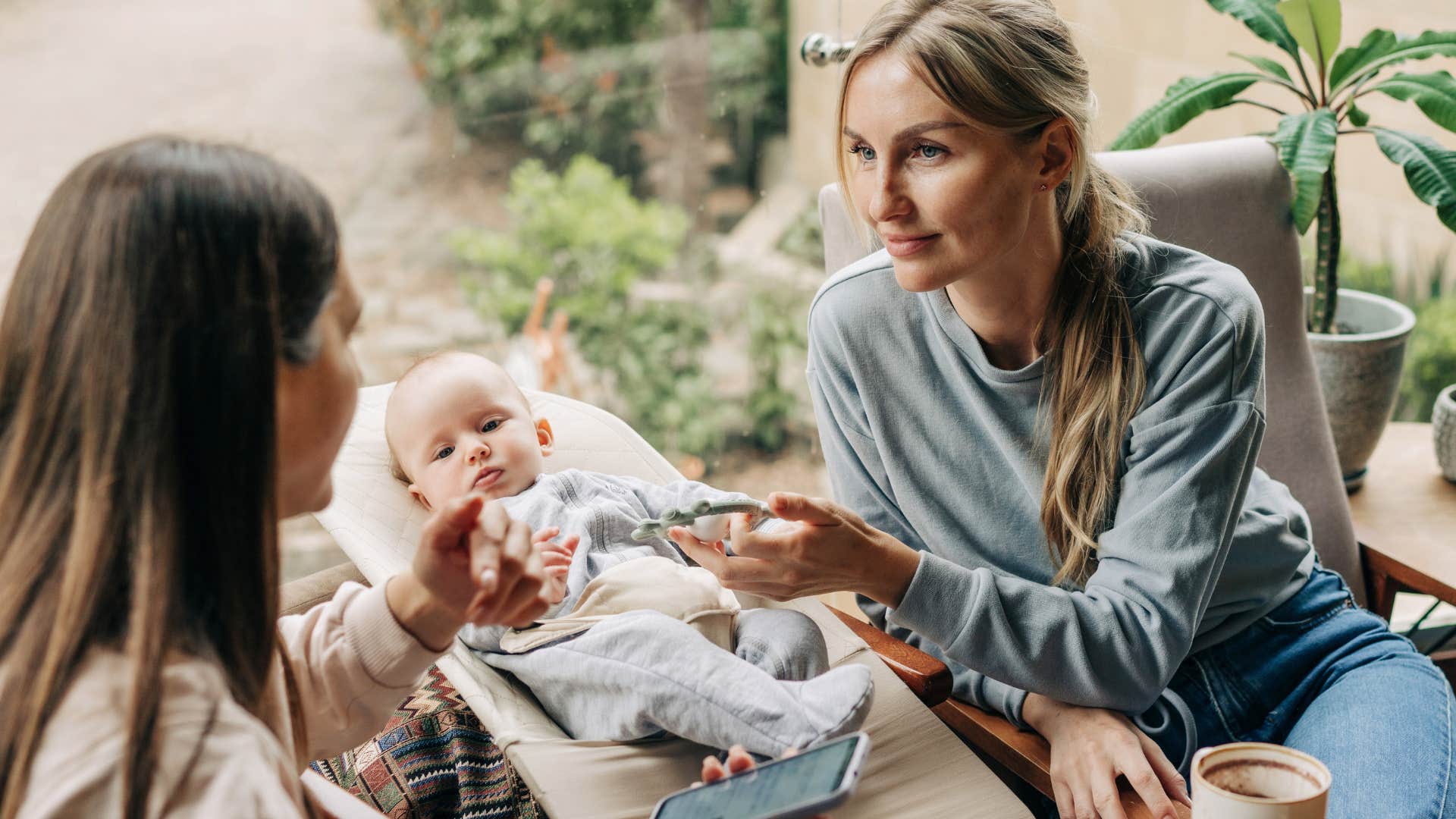 woman and her friend playing with baby