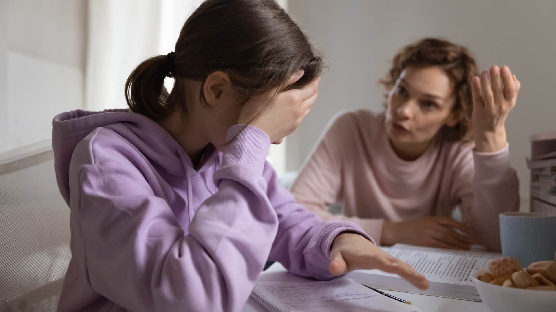 upset mother scolding teen daughter