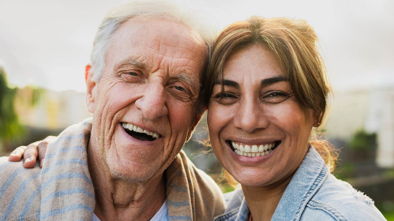 middle aged woman smiling next to her boomer dad