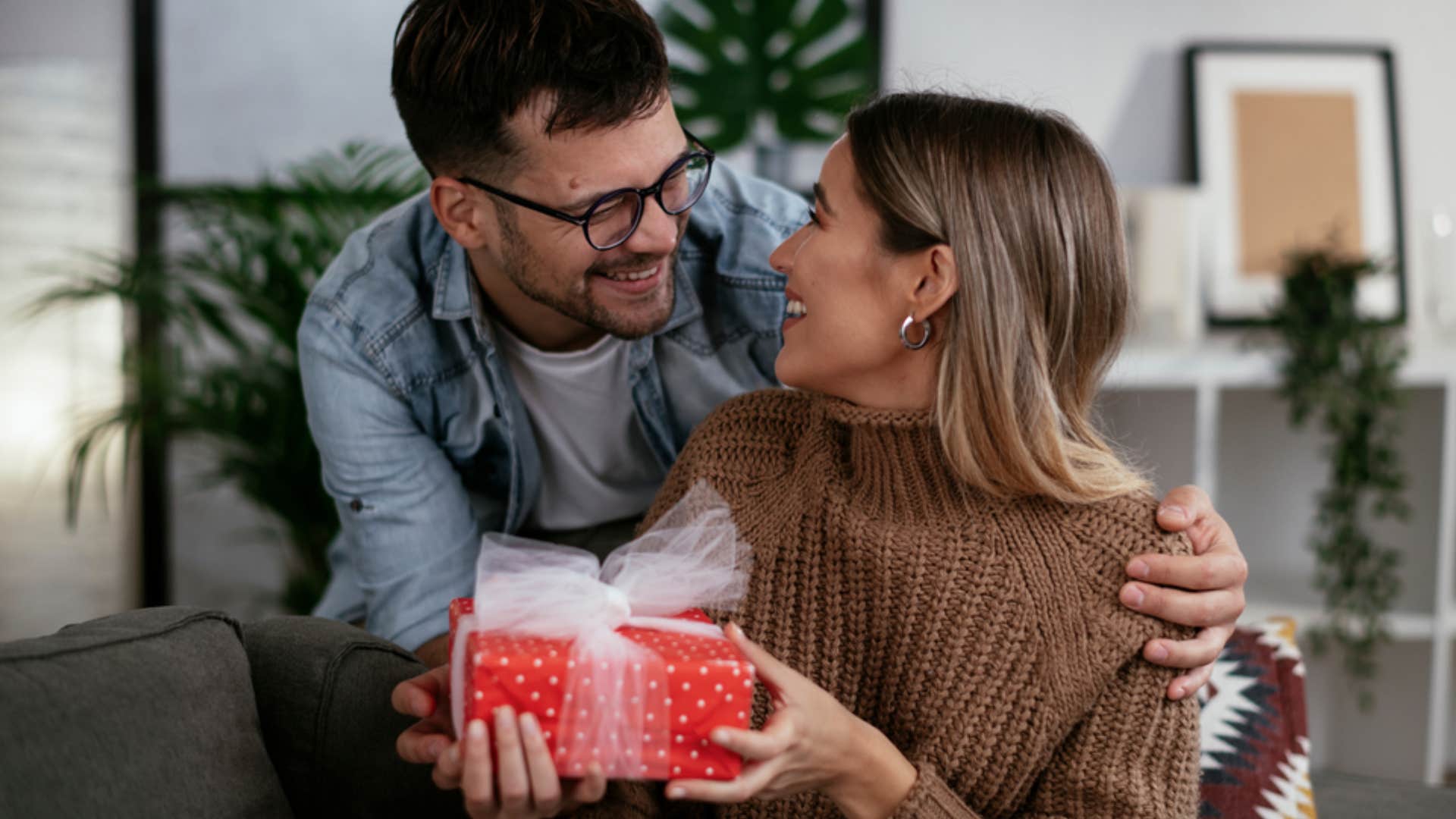 man surprising woman with a gift