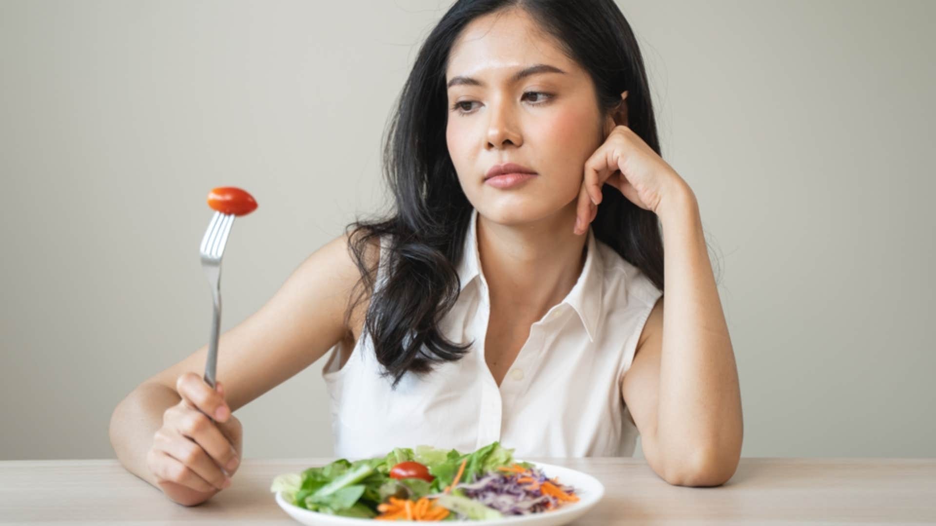 unhappy woman looking at food not hungry