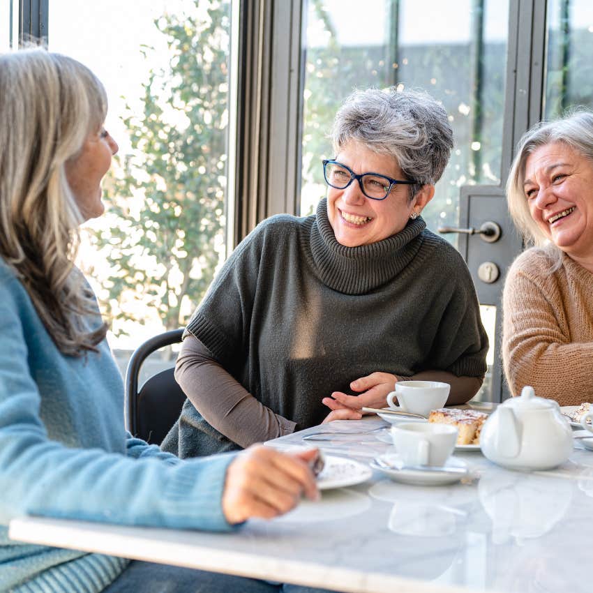 older boomer women laughing and having coffee