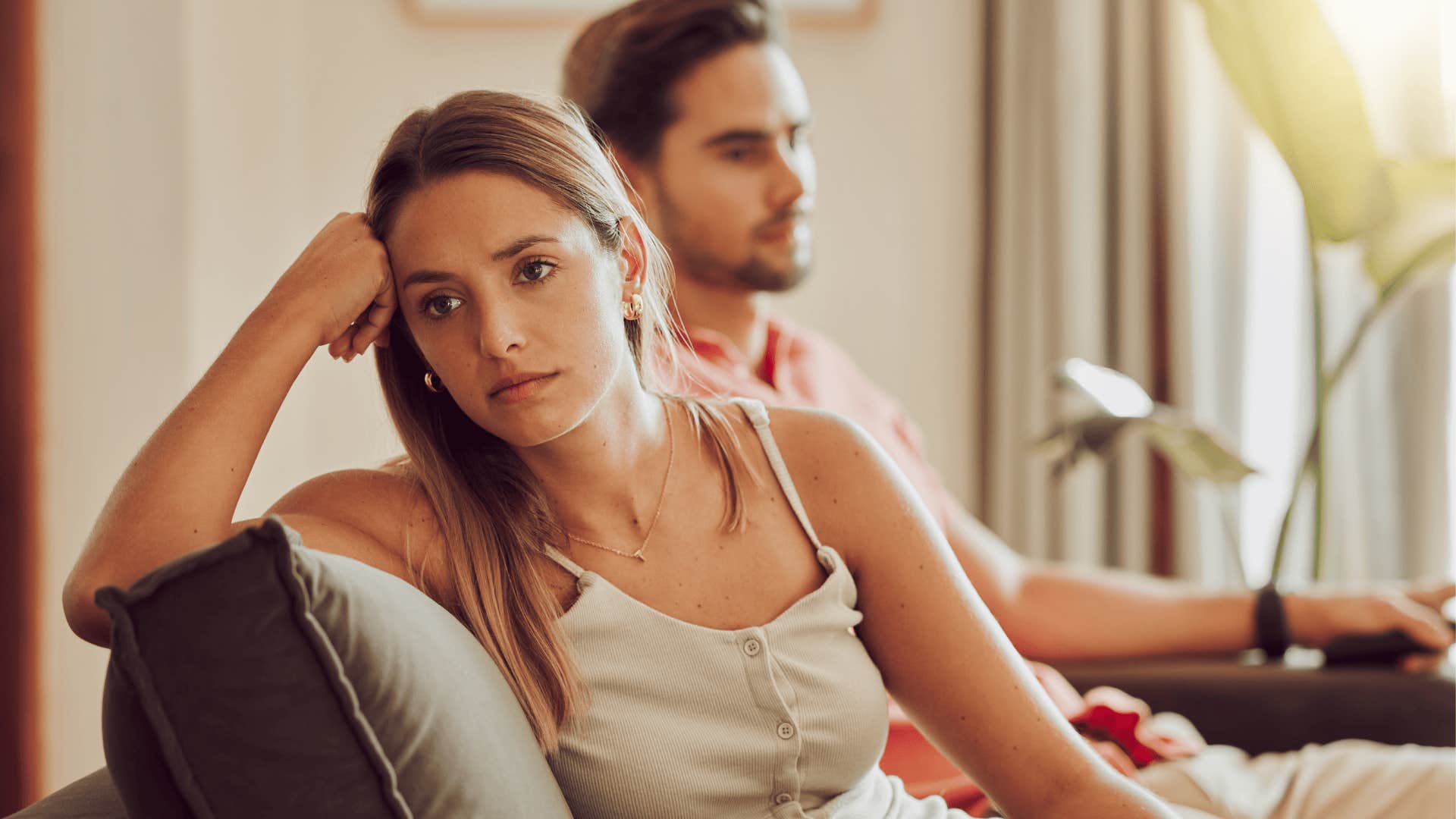 upset woman sitting next to spouse whose battery is low