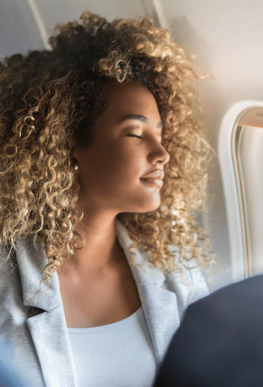 Woman sleeping while passenger behind her touched her hair