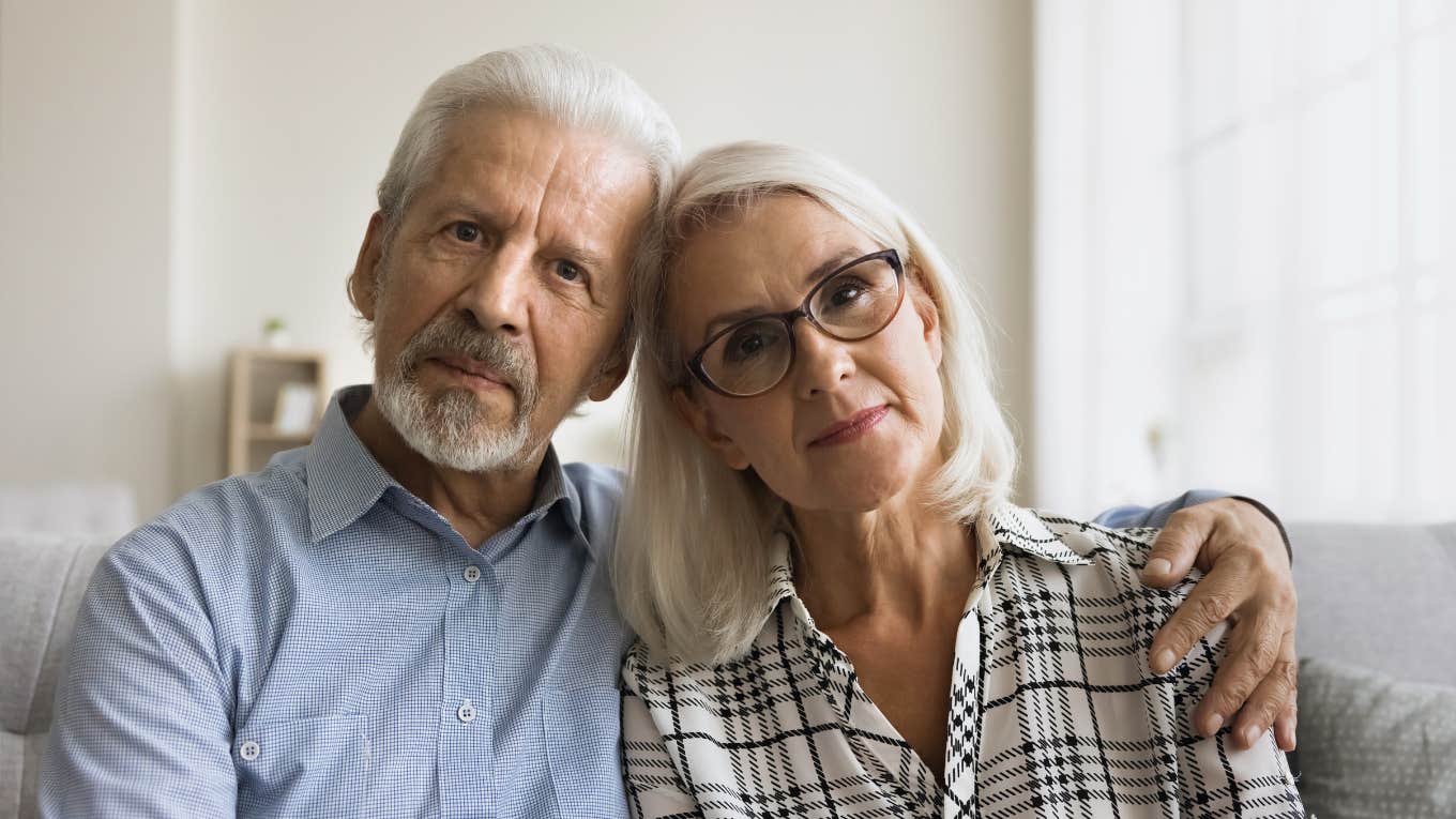 serious boomer couple looking unhappy