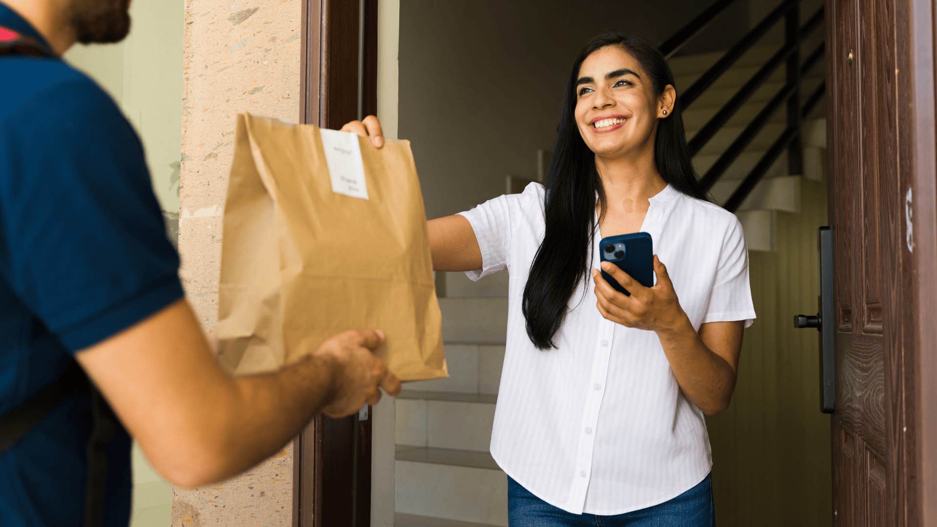 Woman receiving a food delivery at her front door