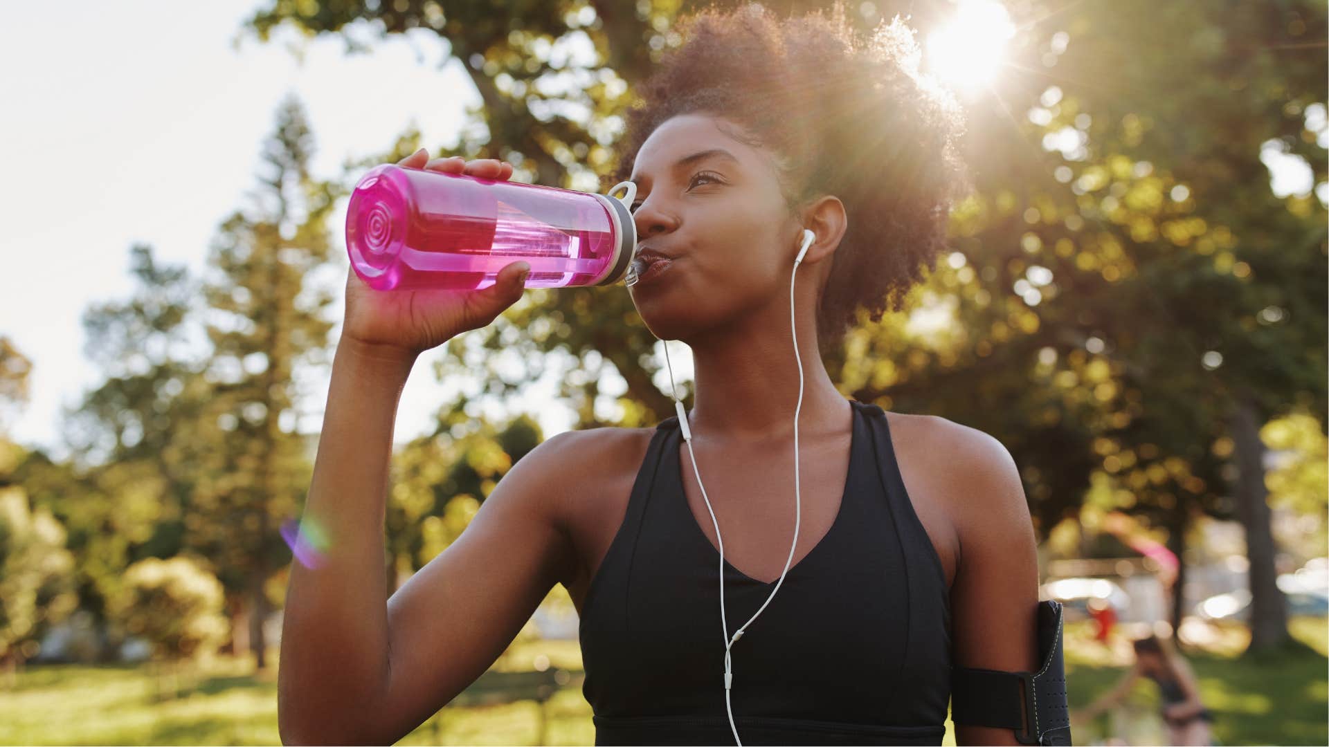 frugal woman drinking out of a reusable water bottle