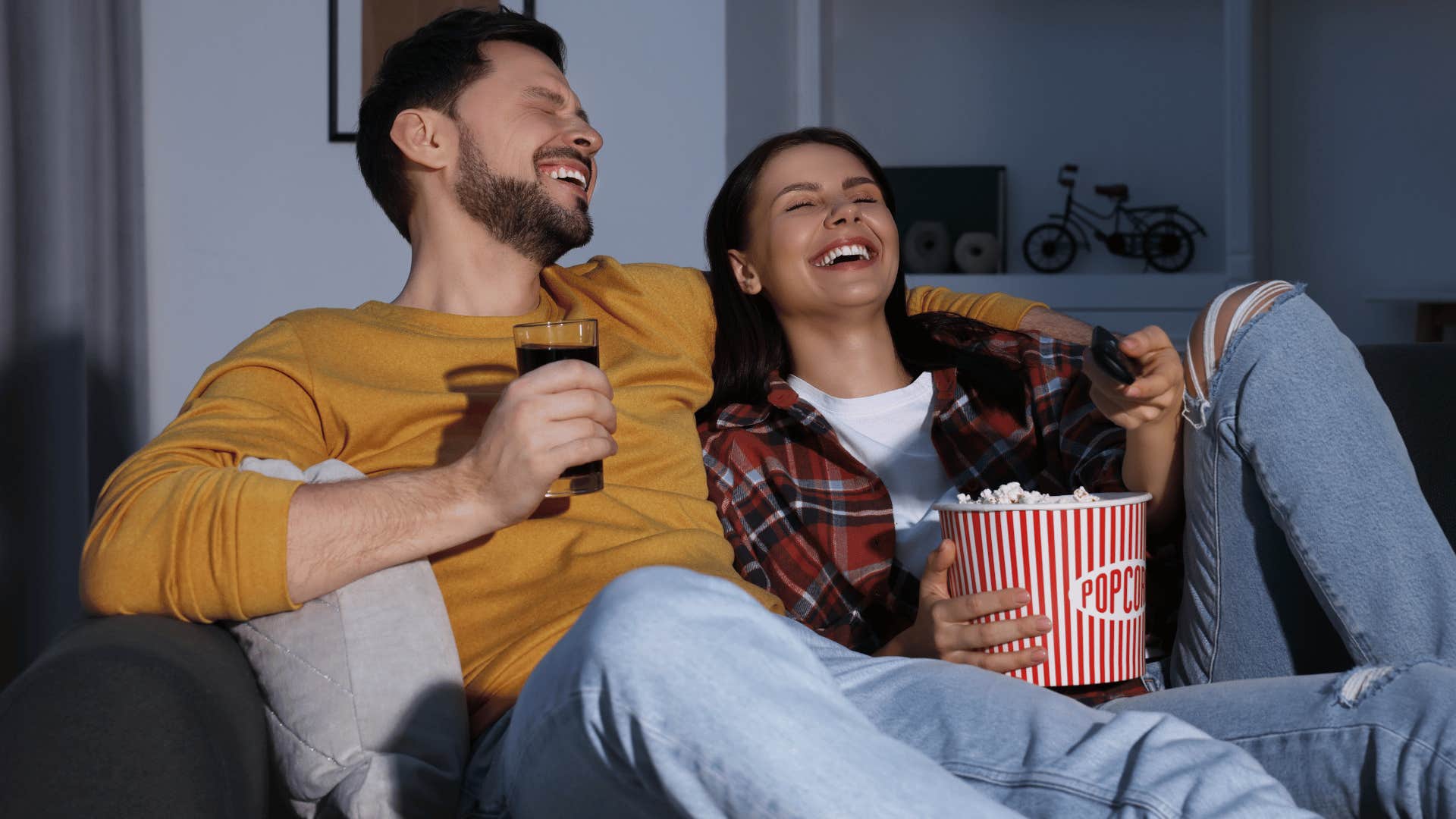 Gen X couple laughing at offensive humor on TV