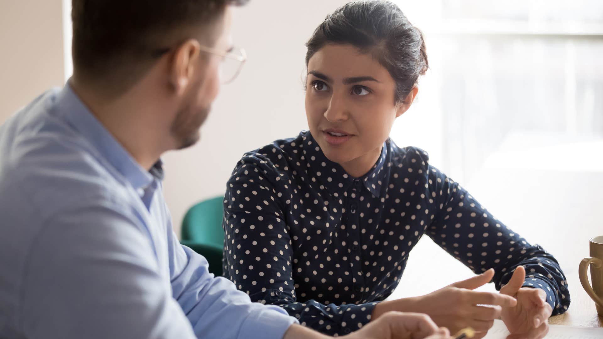 assertive Gen Z woman having serious conversation with colleague