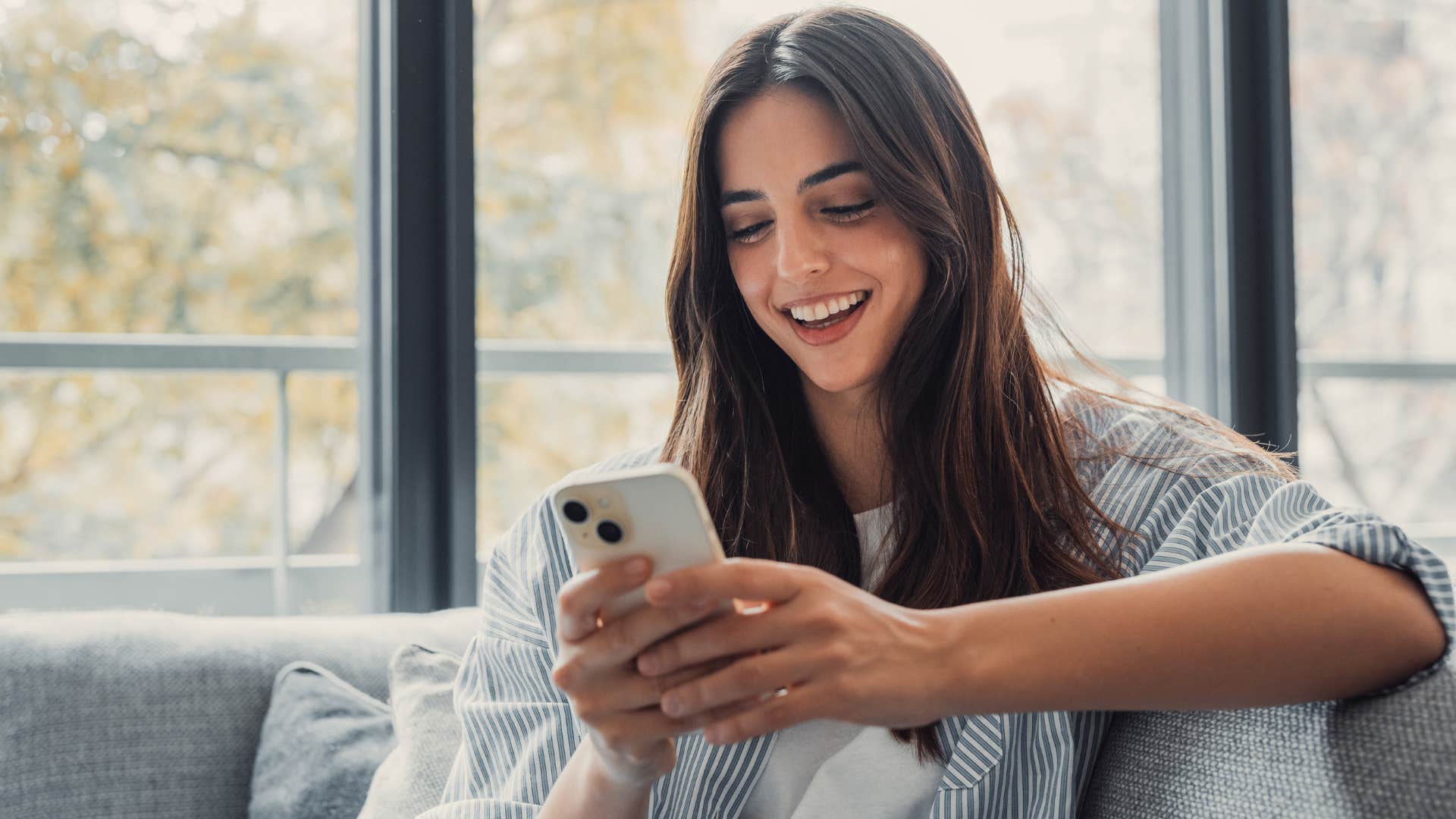 young woman smiling and texting