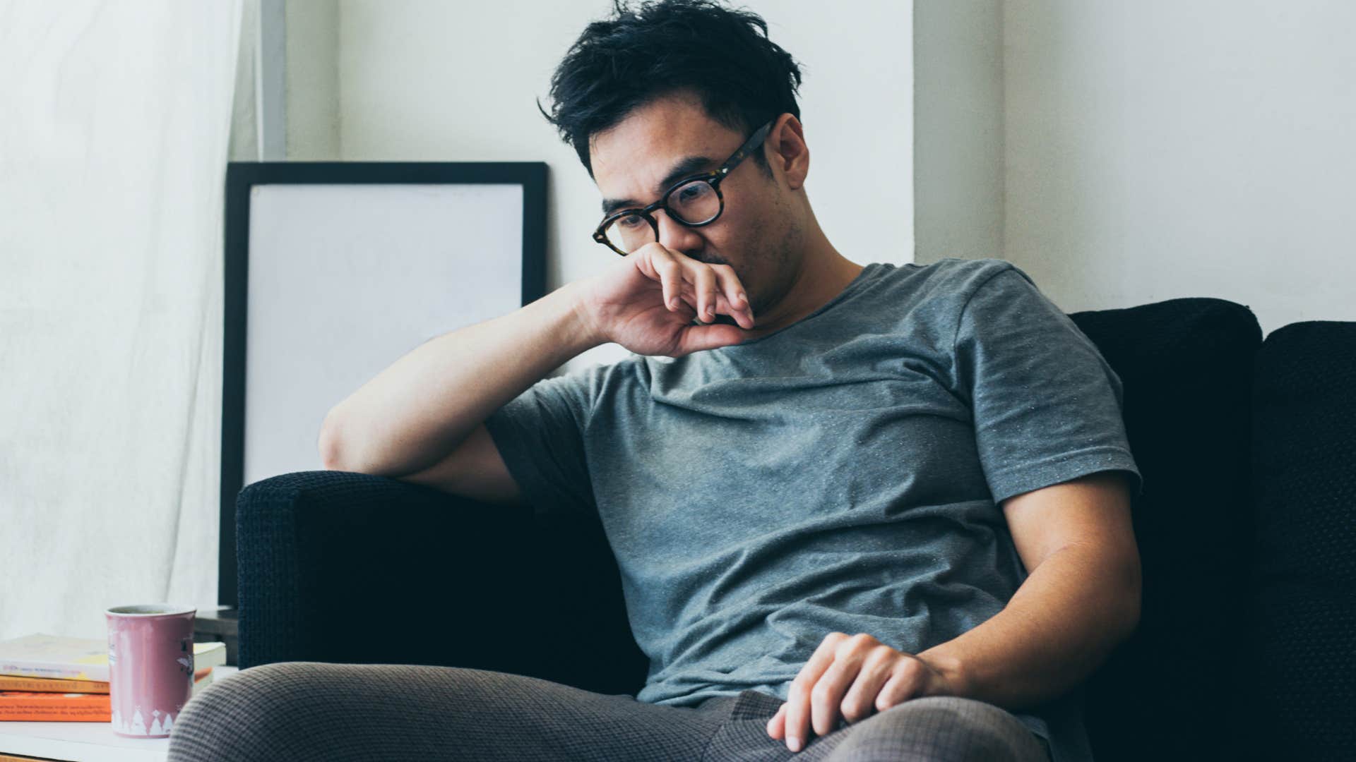 anxious Gen Z man sitting on the couch