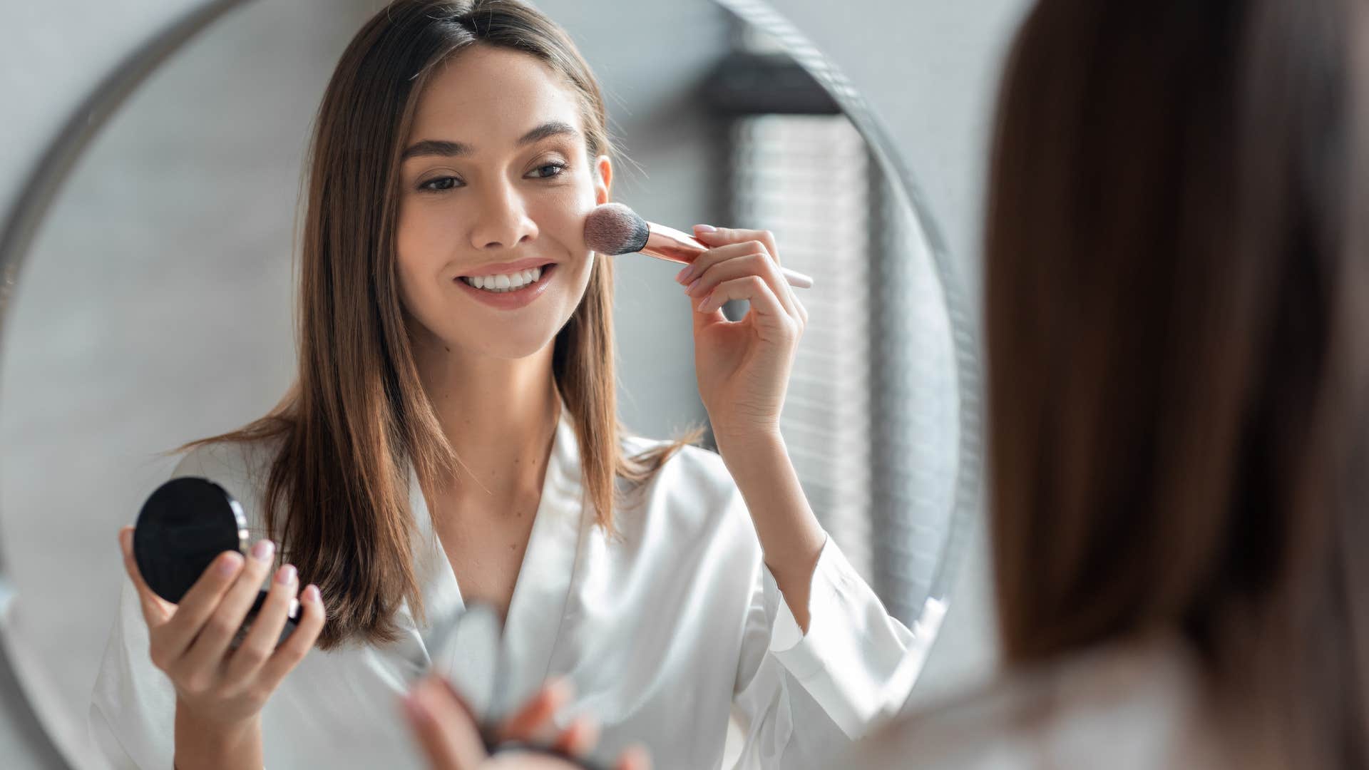 conventionally attractive gen z woman putting on makeup