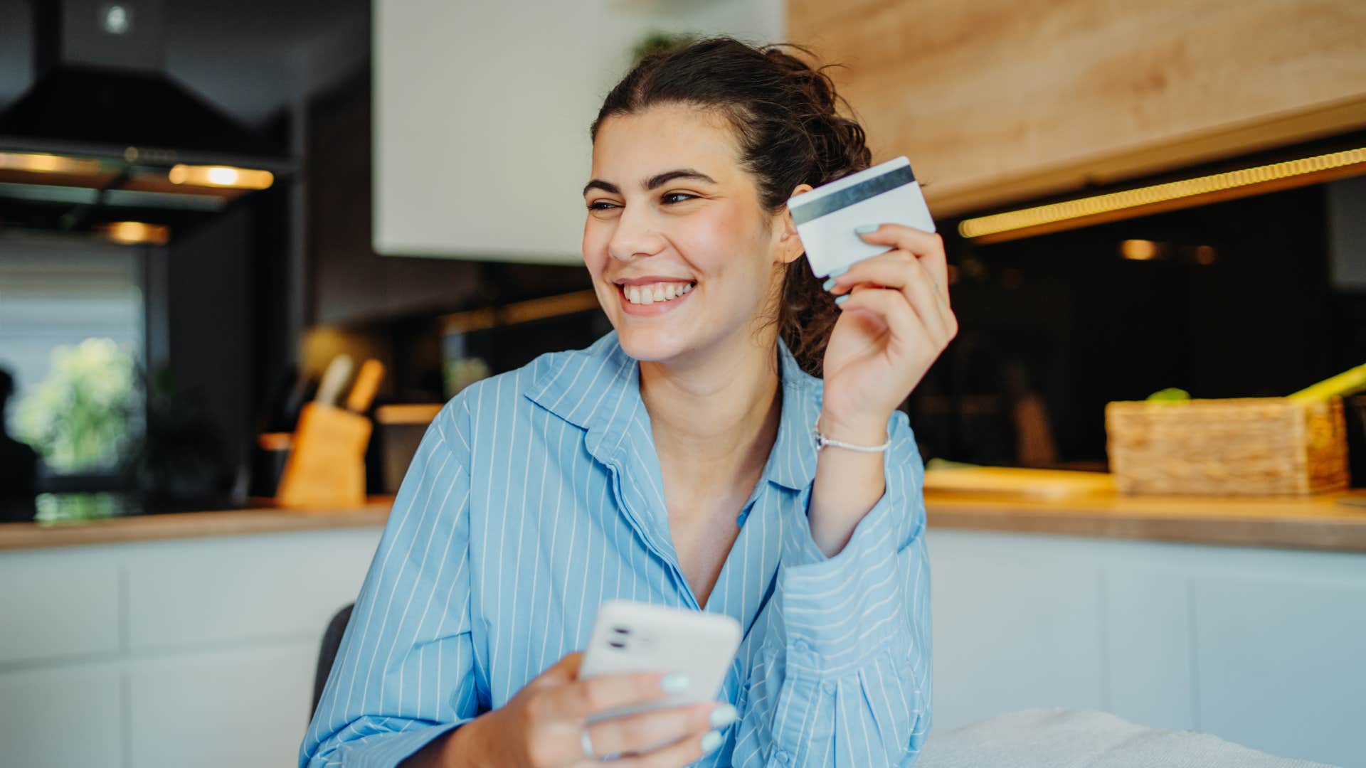 gen z woman holding up her credit card