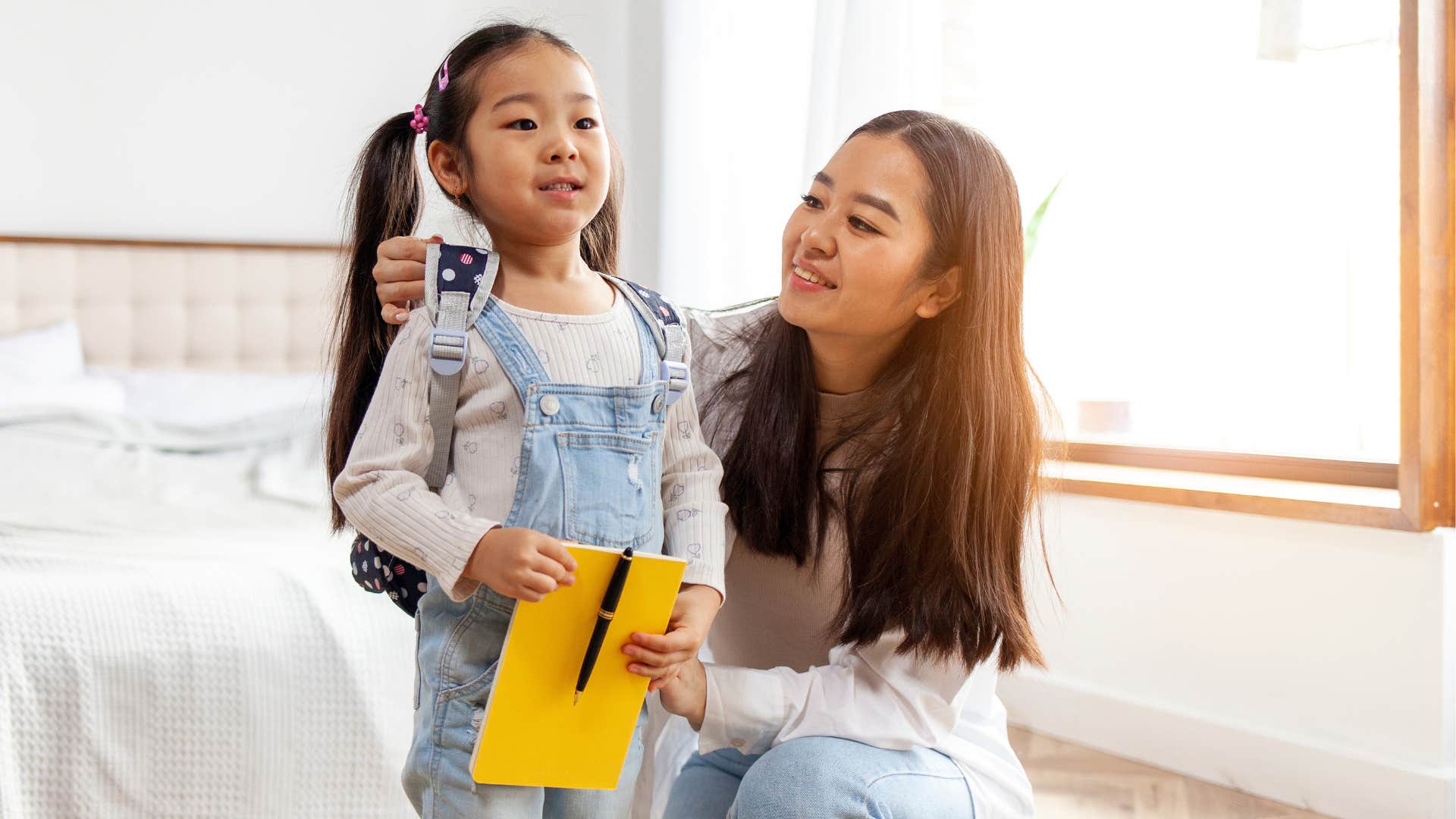 A mother gets her daughter ready for her first day of school after buying supplies.
