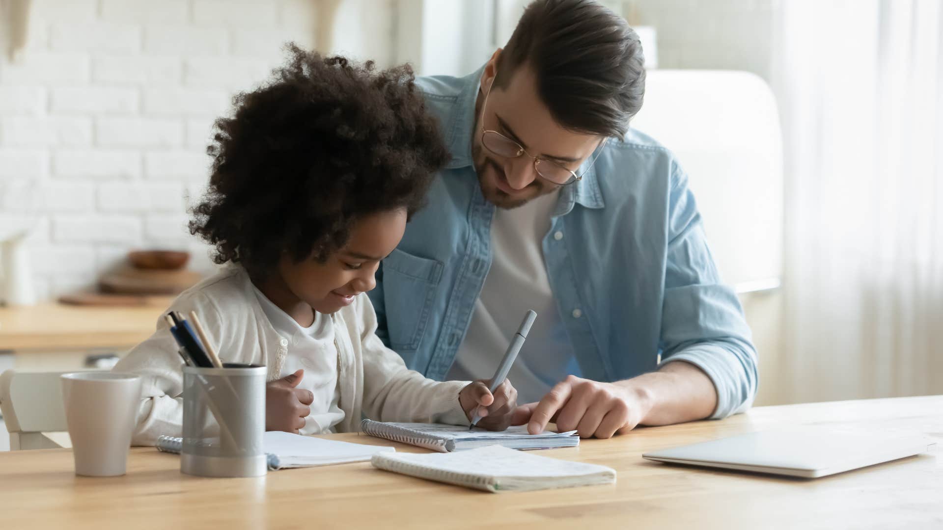 A father helps his daughter with her homework despite working all day.