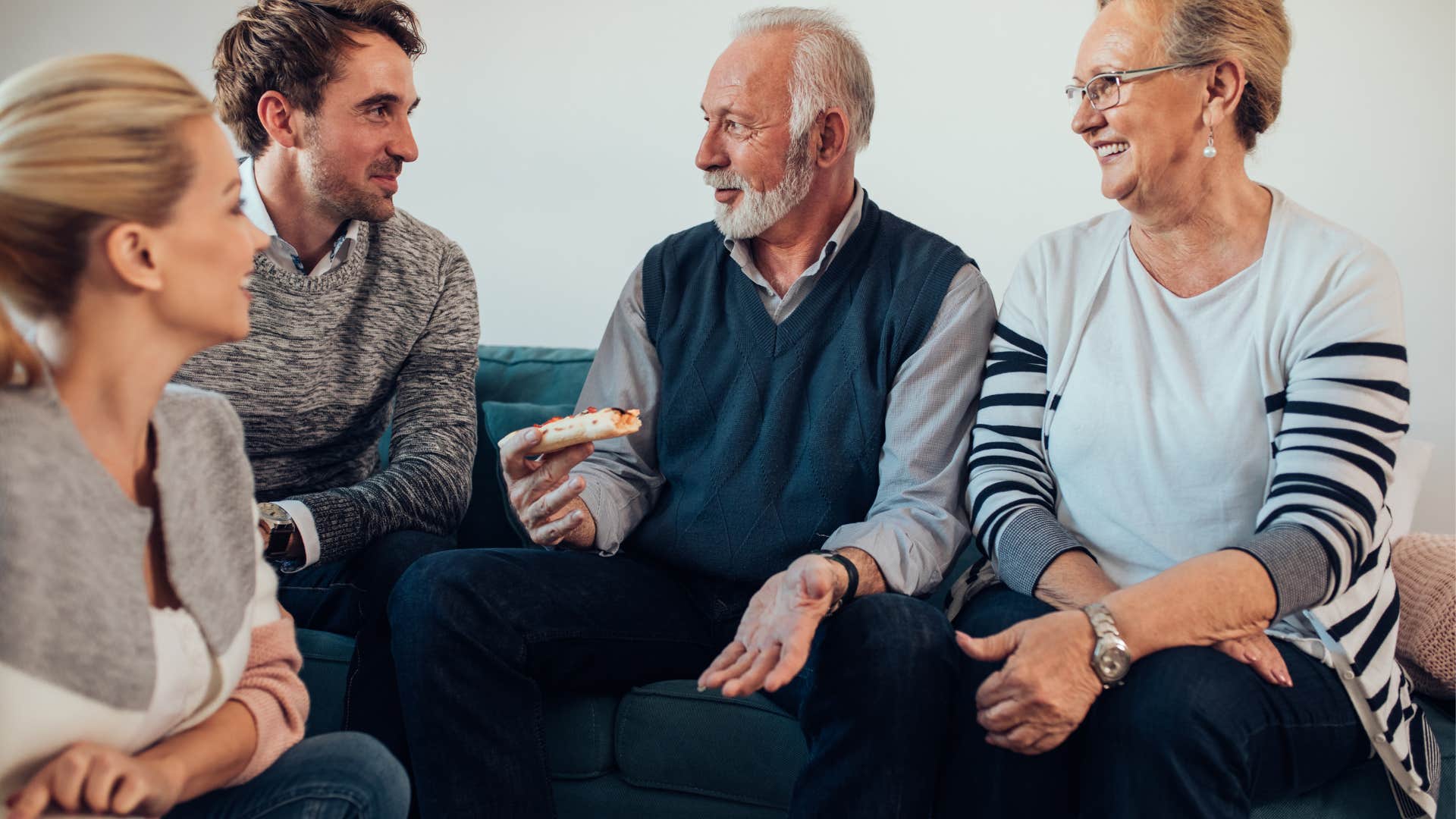 Two older adult children reminisce with their parents over their childhood.
