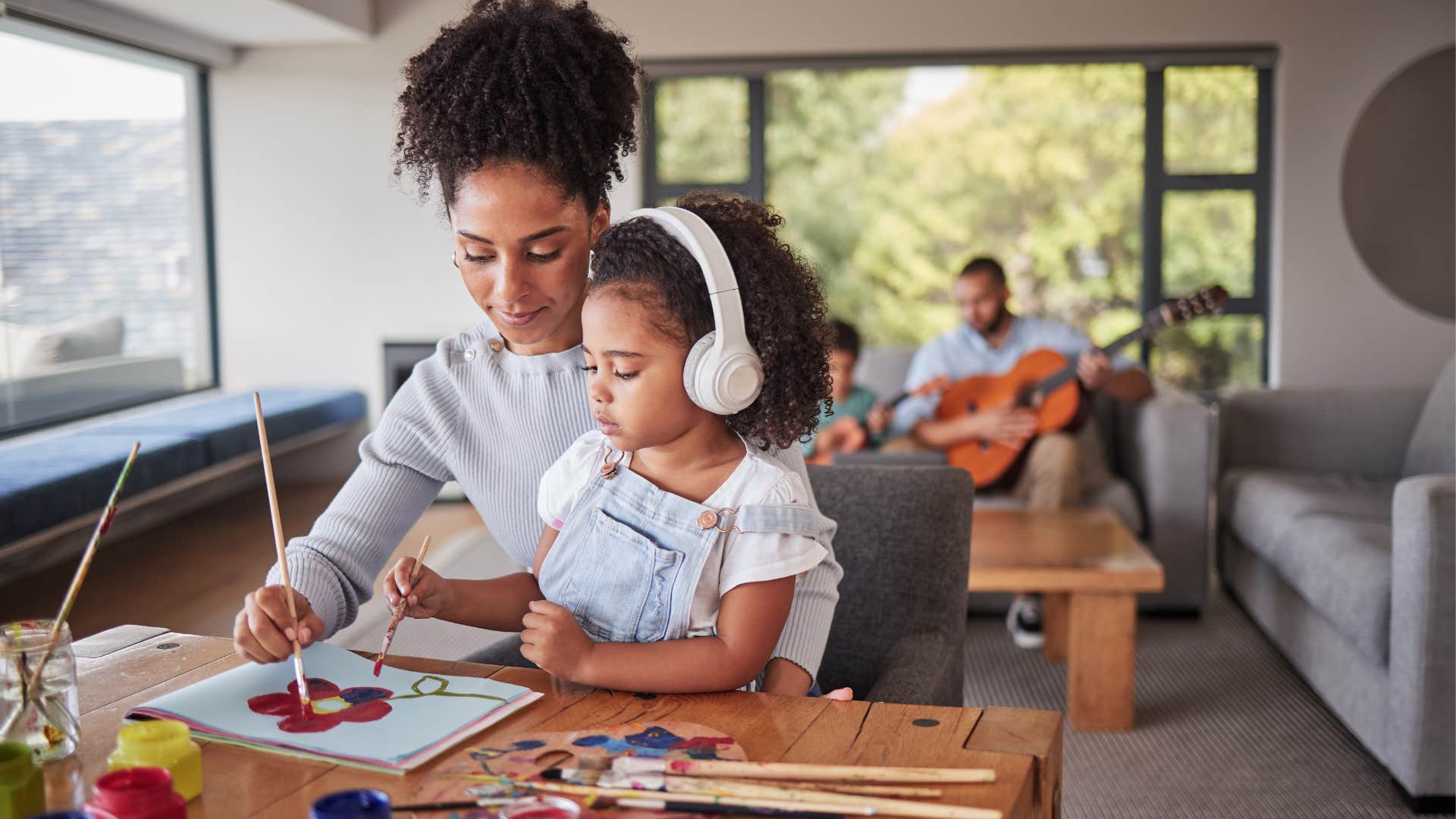 A mom quietly supports her daughter during arts and crafts time.