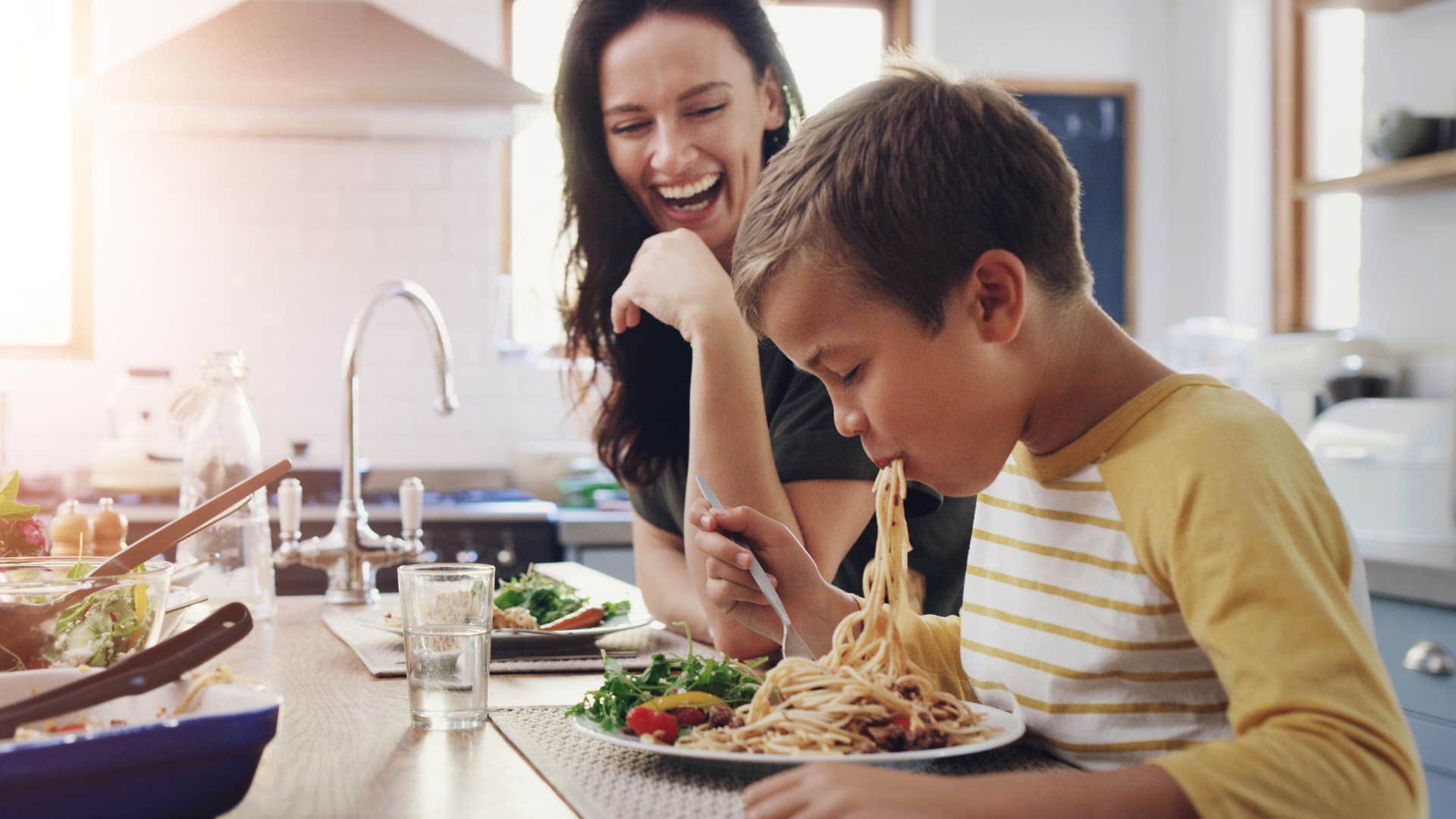 A mom laughs showing her sense of humor to her son.