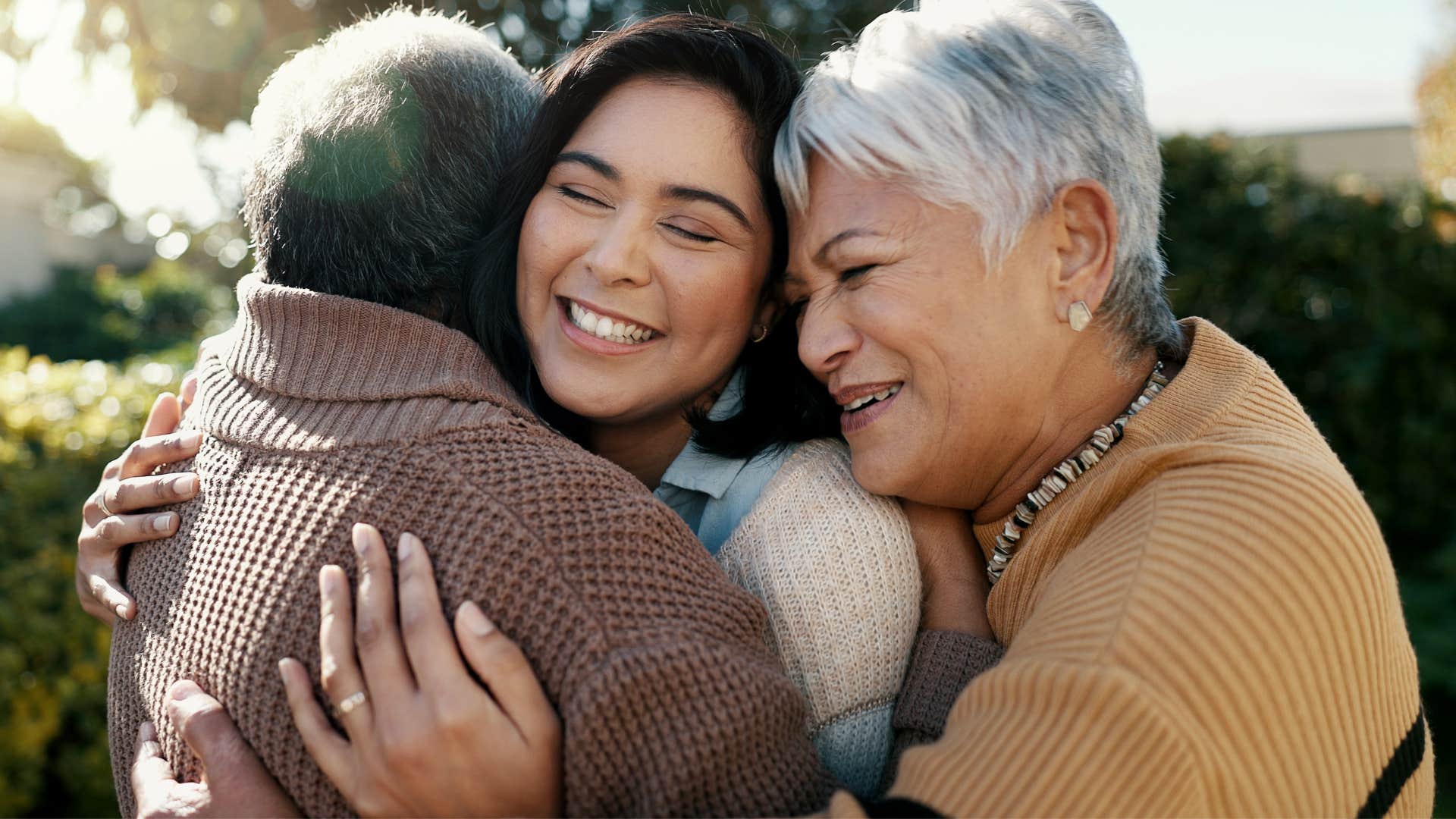 Parents hug their adult daughter after knowing she was upset.