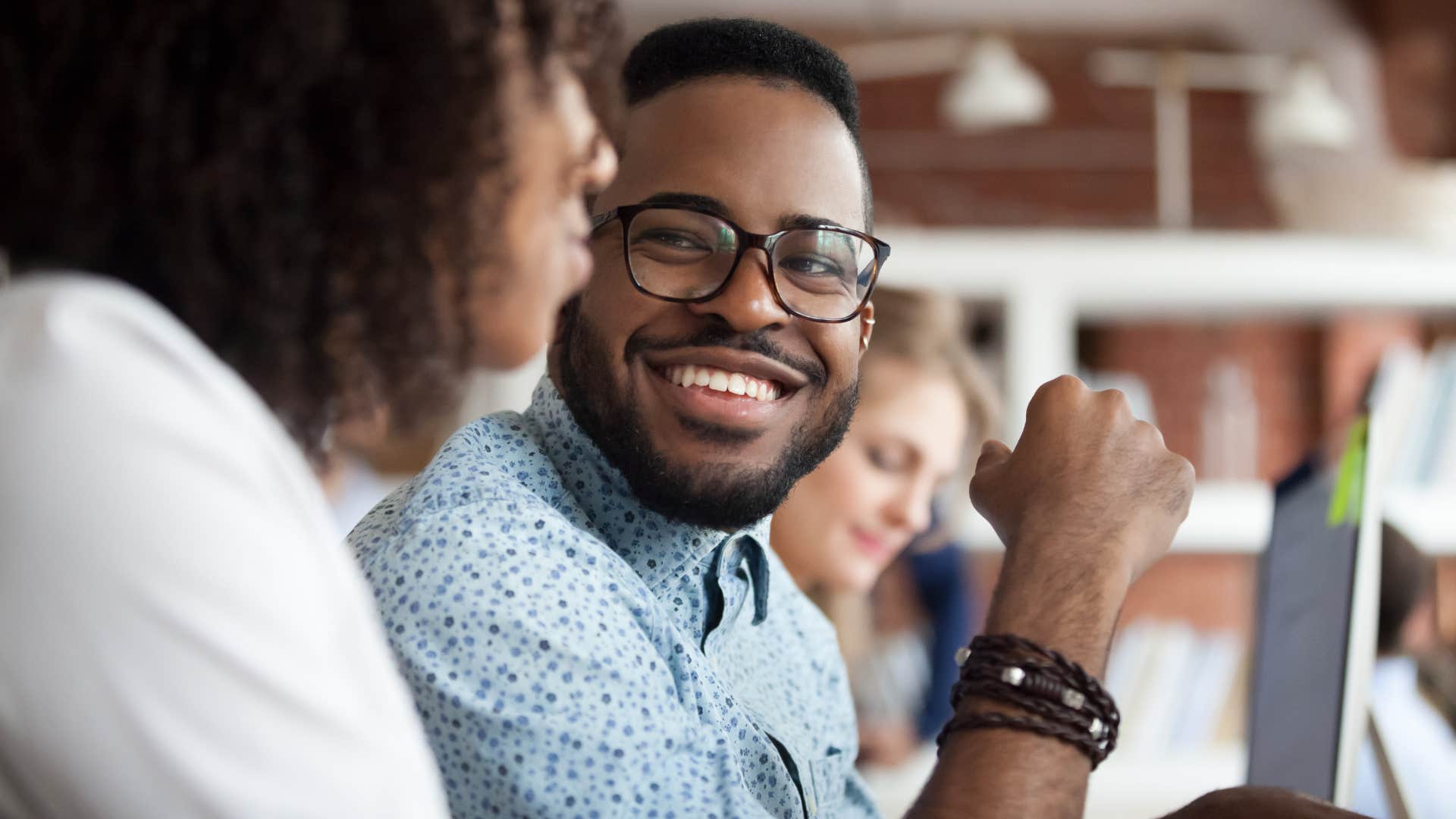 man smiling at his peer in a work meeting
