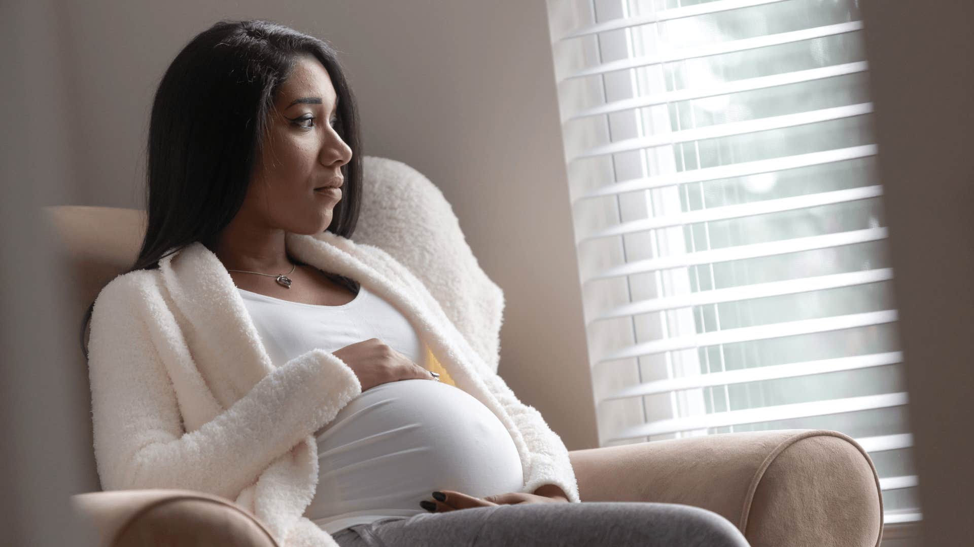 sad pregnant woman staring outside