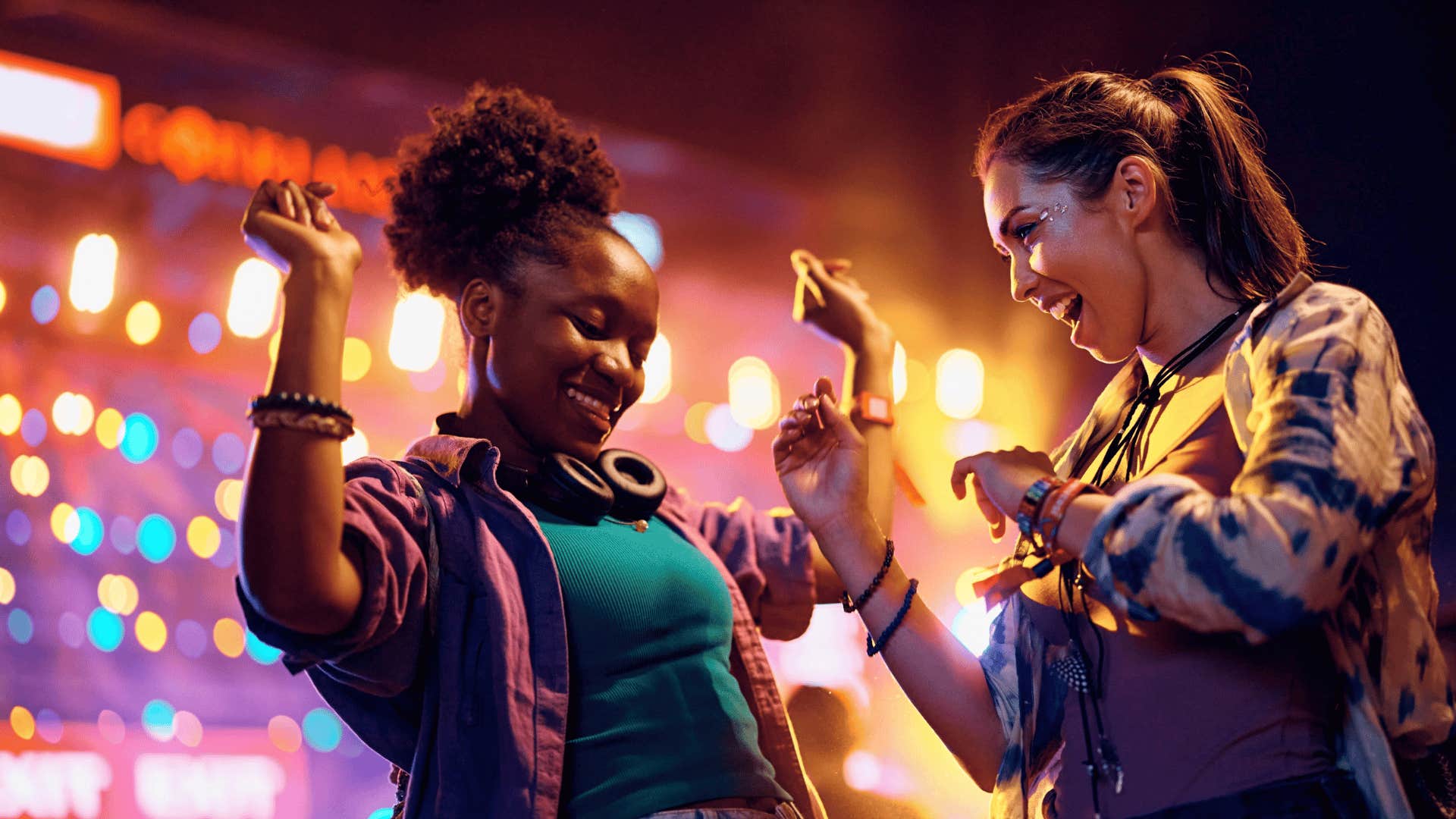 millennial women at music festival dancing
