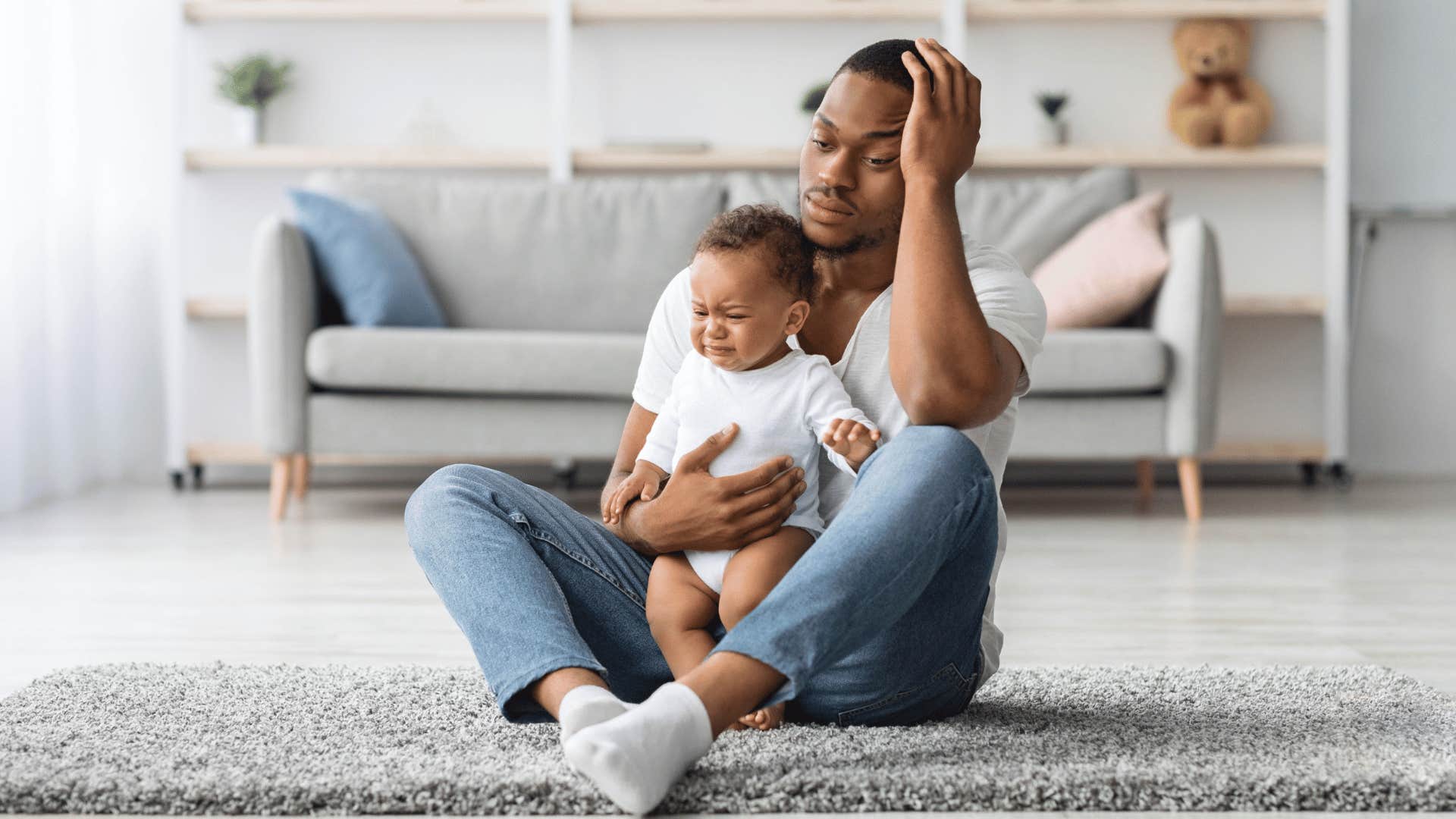 stressed millennial man holding upset baby