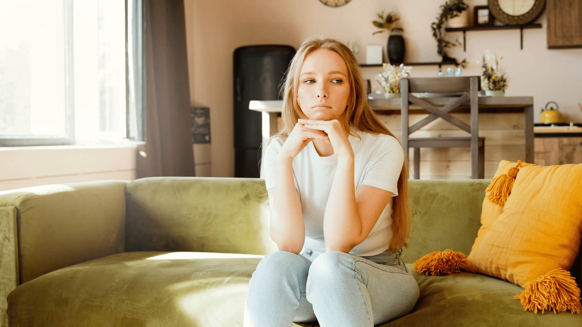 millennial woman looking stressed on a couch