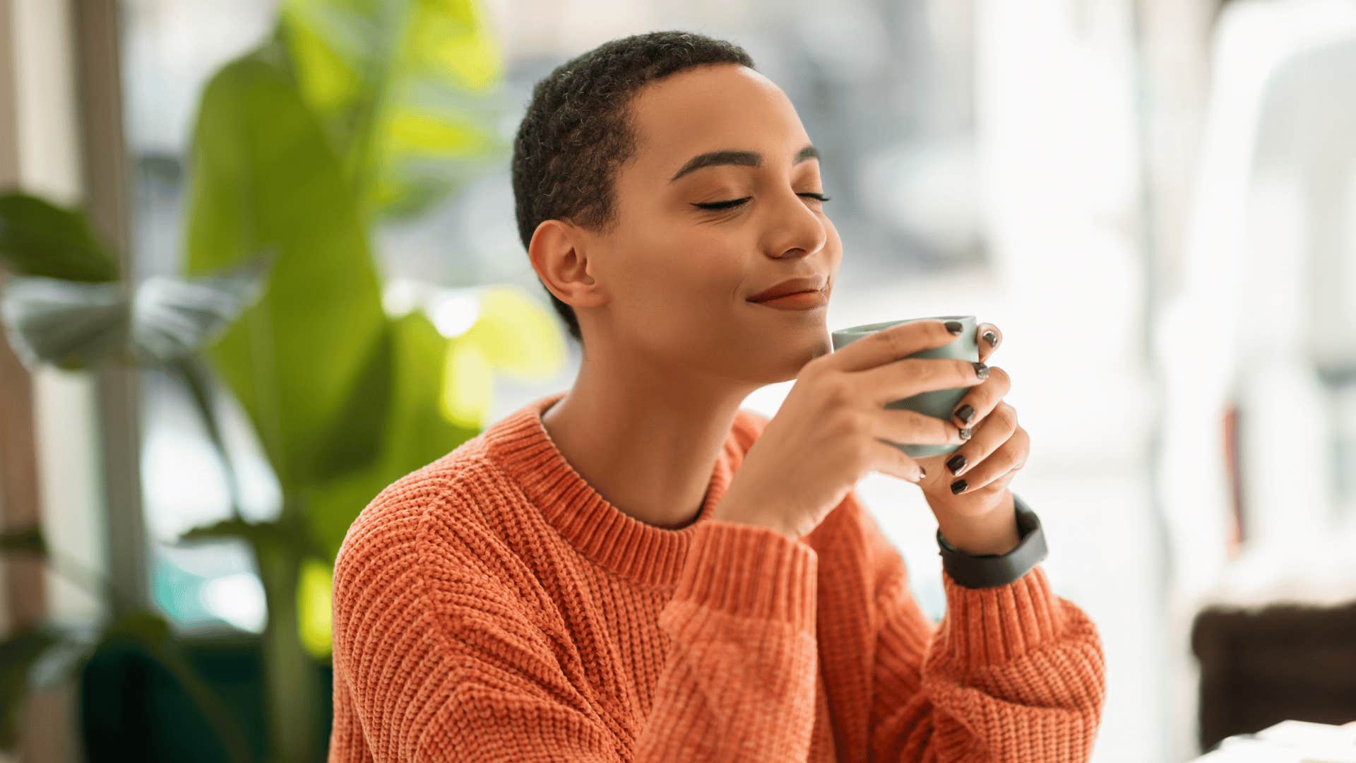 peaceful millennial woman sipping coffee