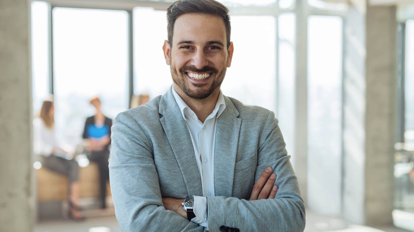 Professional millennial man smiling at the camera in his office.