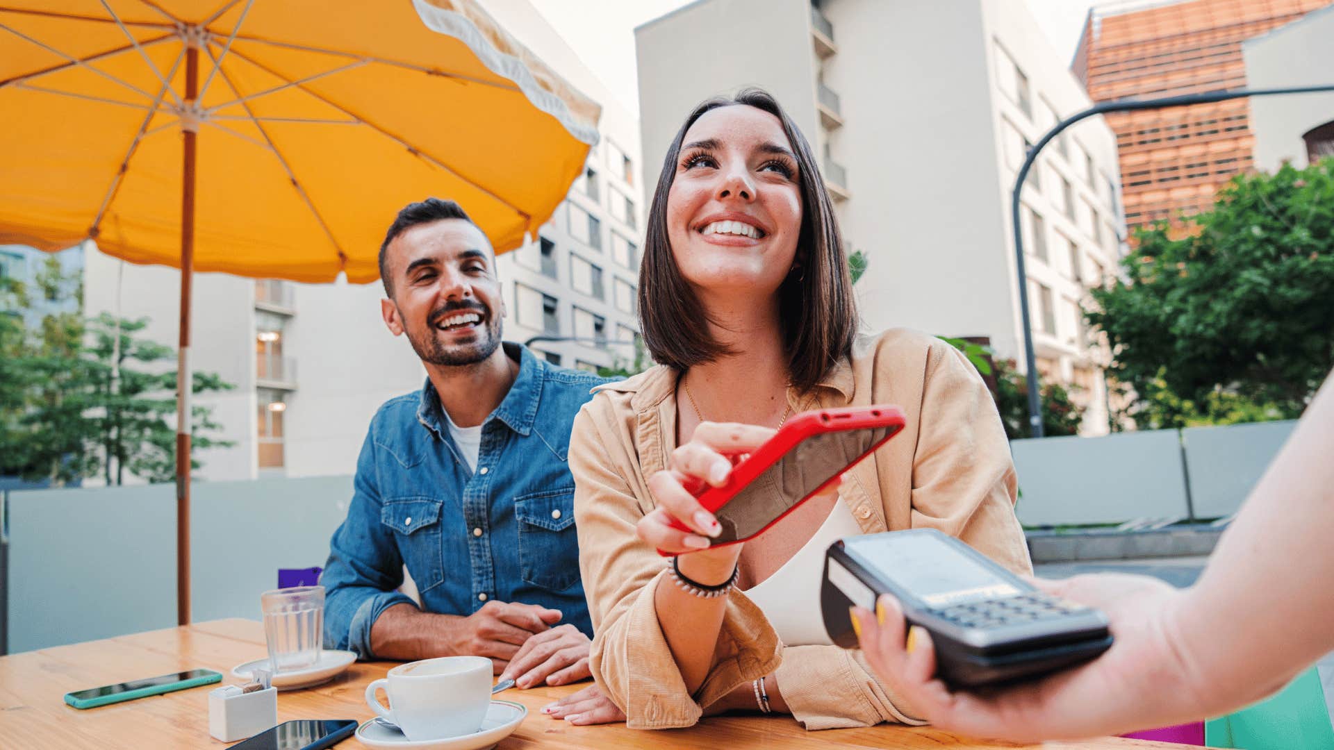 young adult couple spending money at coffee cafe