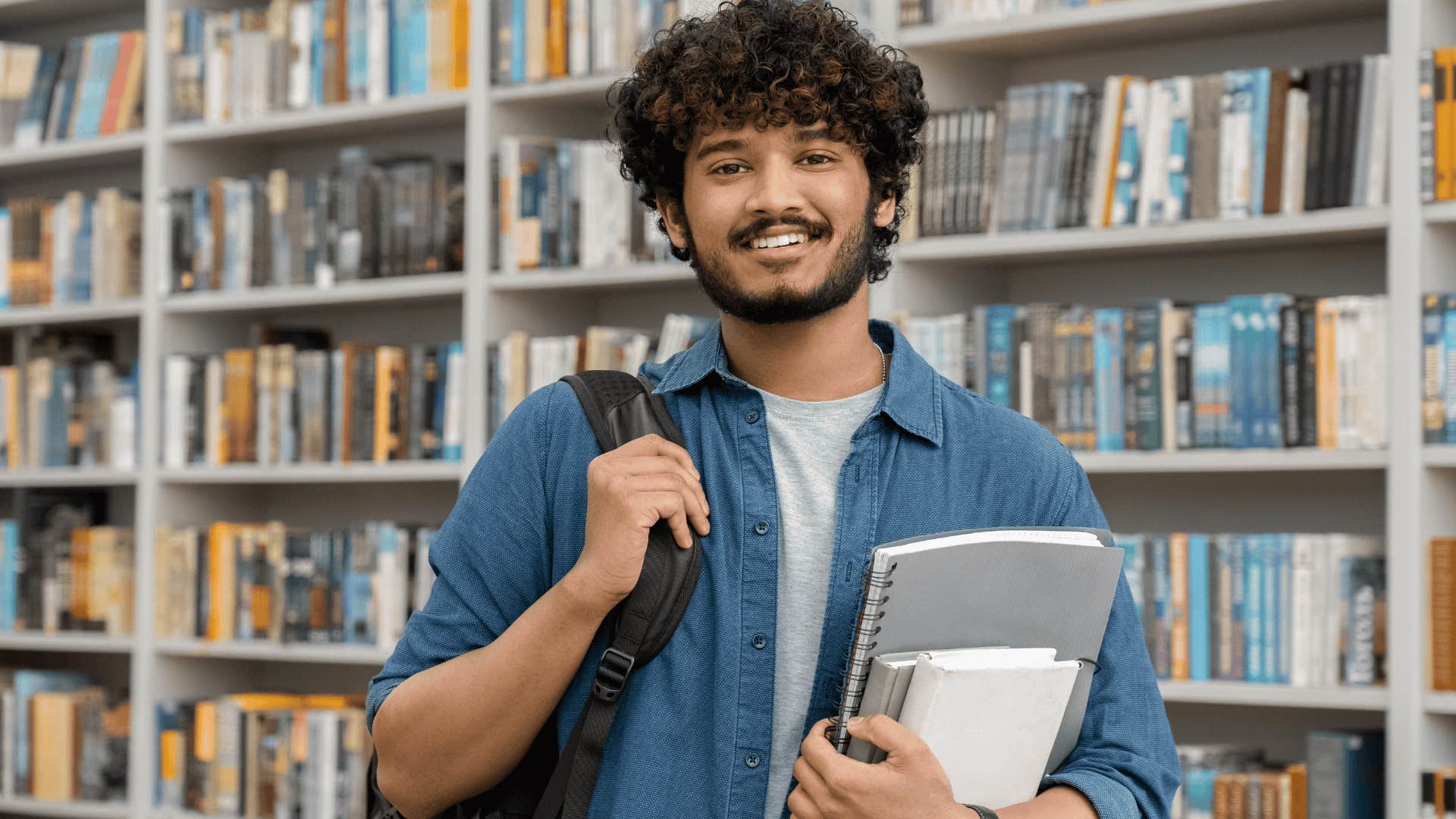 young man smiling in a library