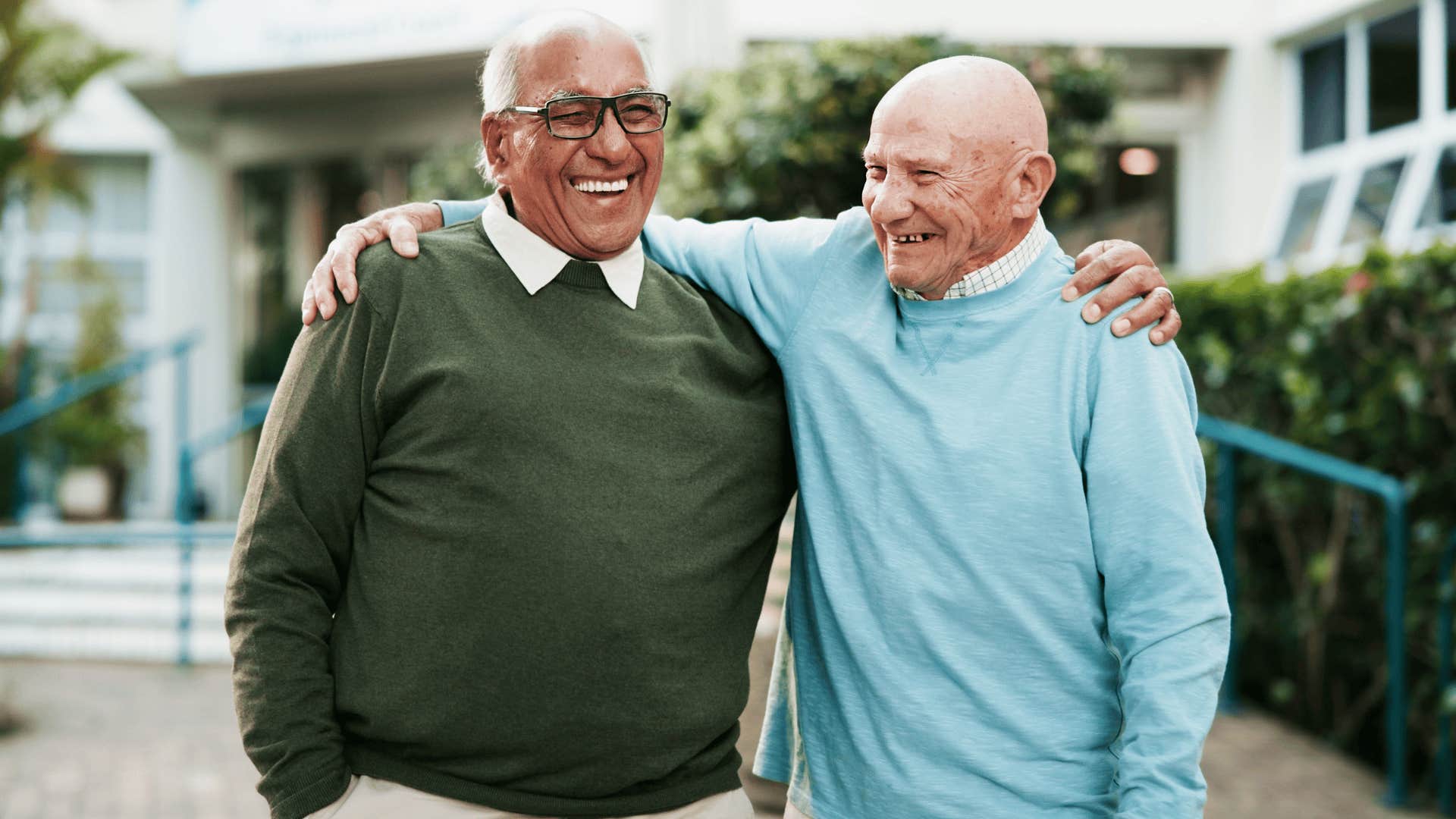 two older men smiling and hugging each other