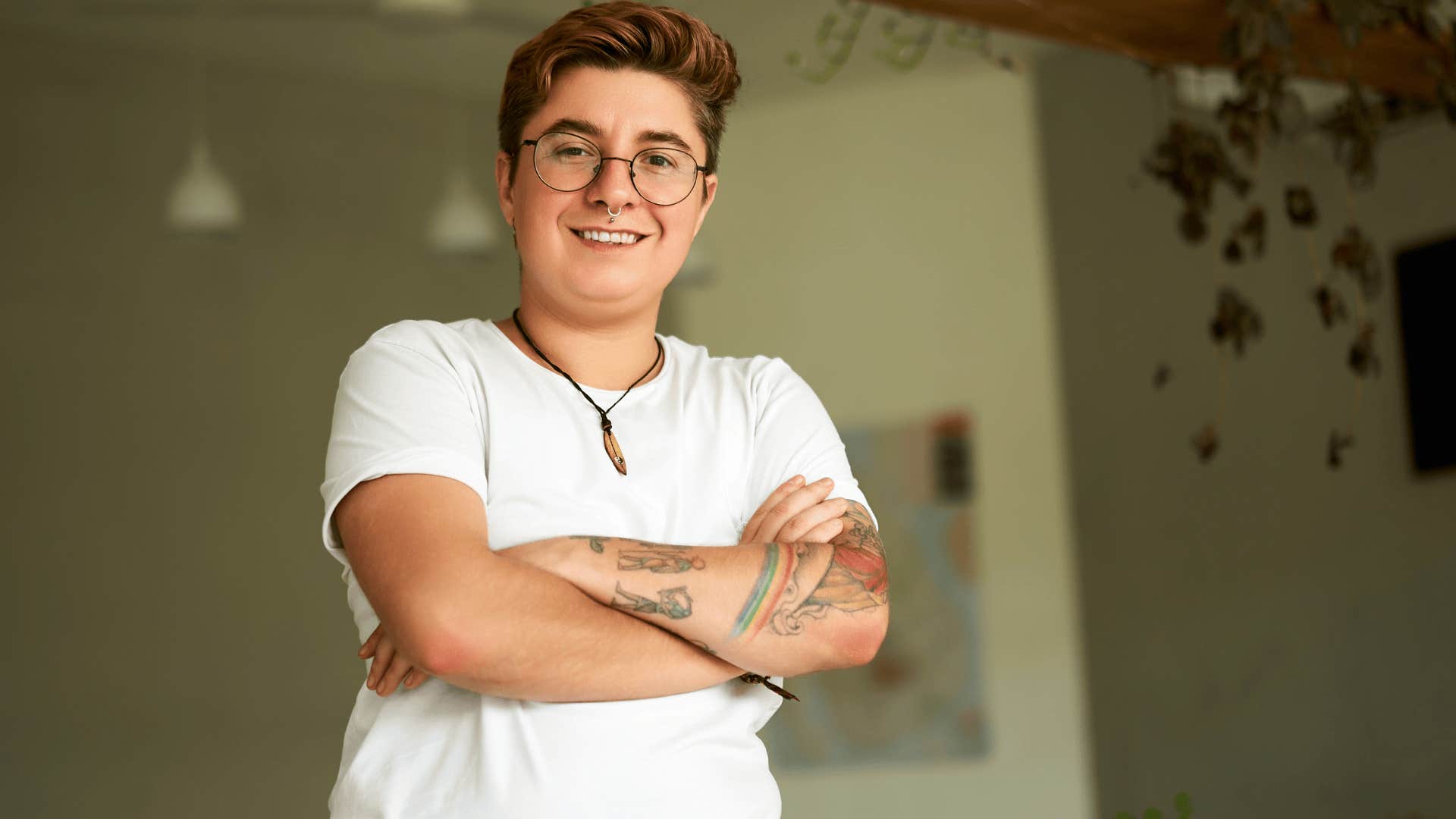 Gen Z person smiling with their arms crossed