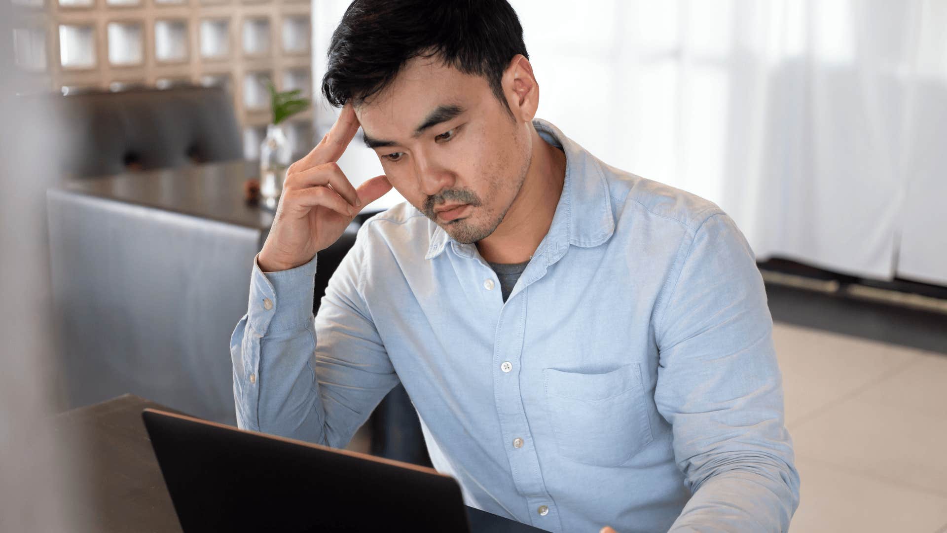 stressed man working on his laptop